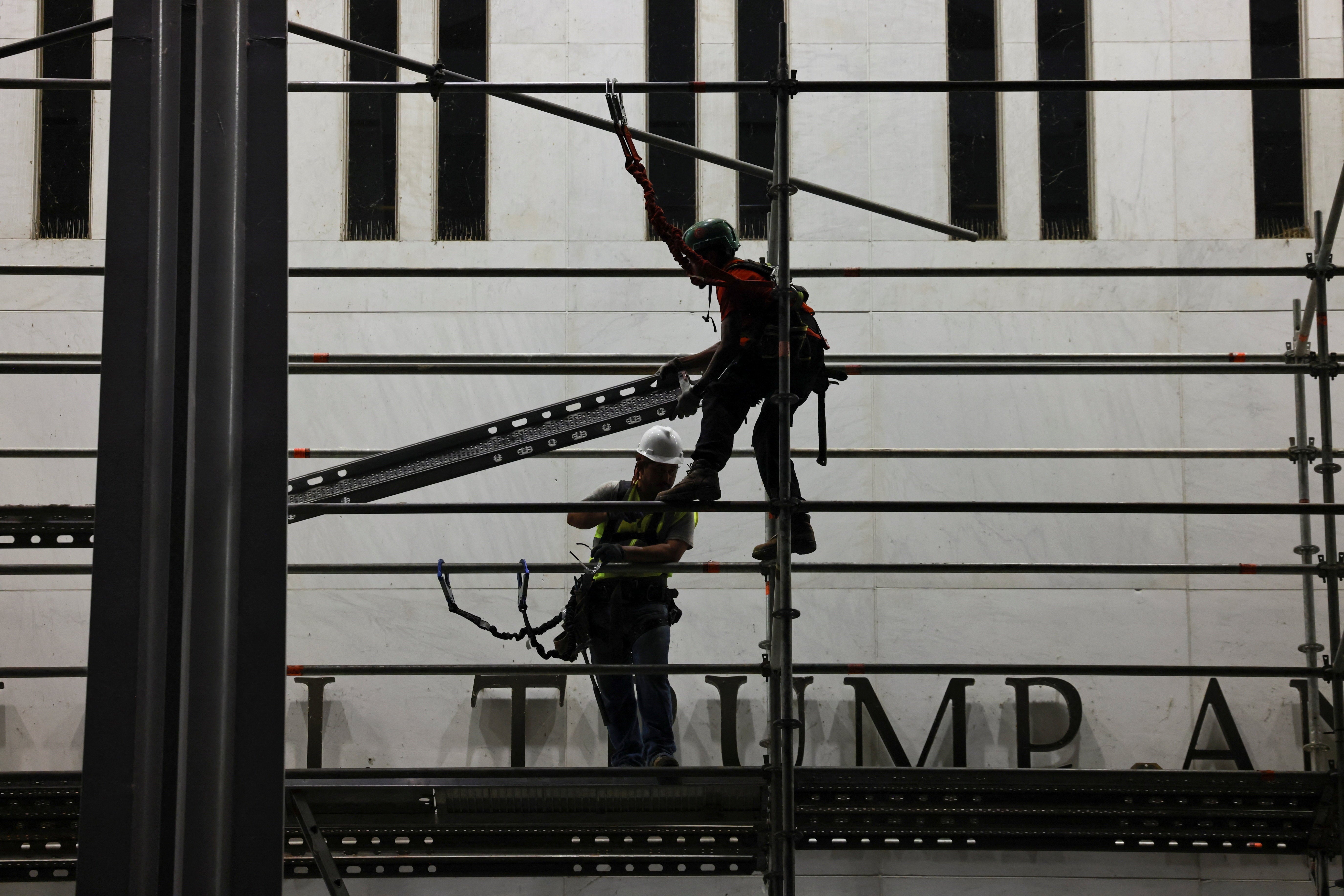 Workers set up scaffolding before removing President Donald Trump’s name from the Kennedy Center last week