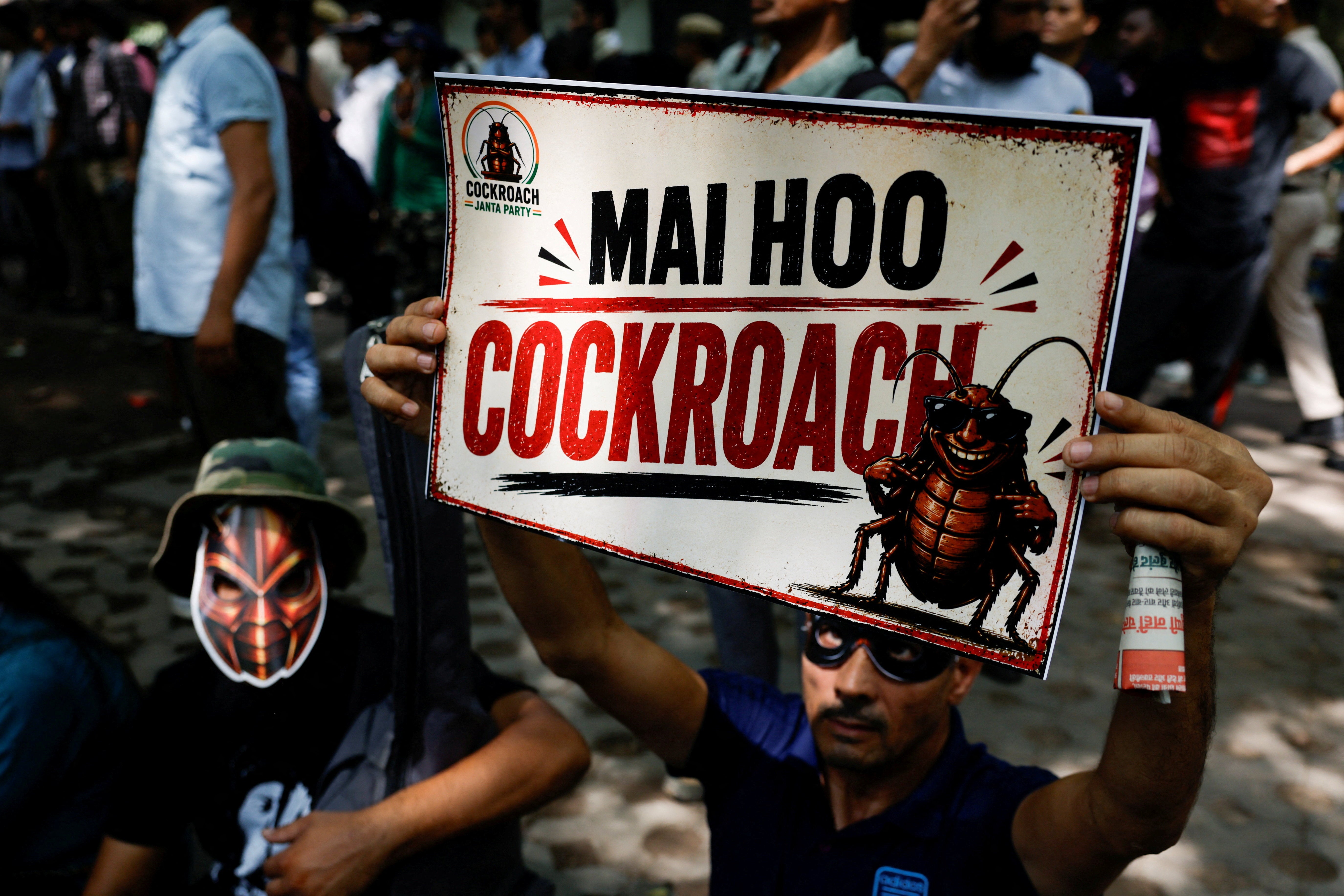 File. A supporter wearing a mask holds a poster during a rally led by Cockroach Janta Party leader Abhijeet Dipke in Delhi, India, on 6 June 2026