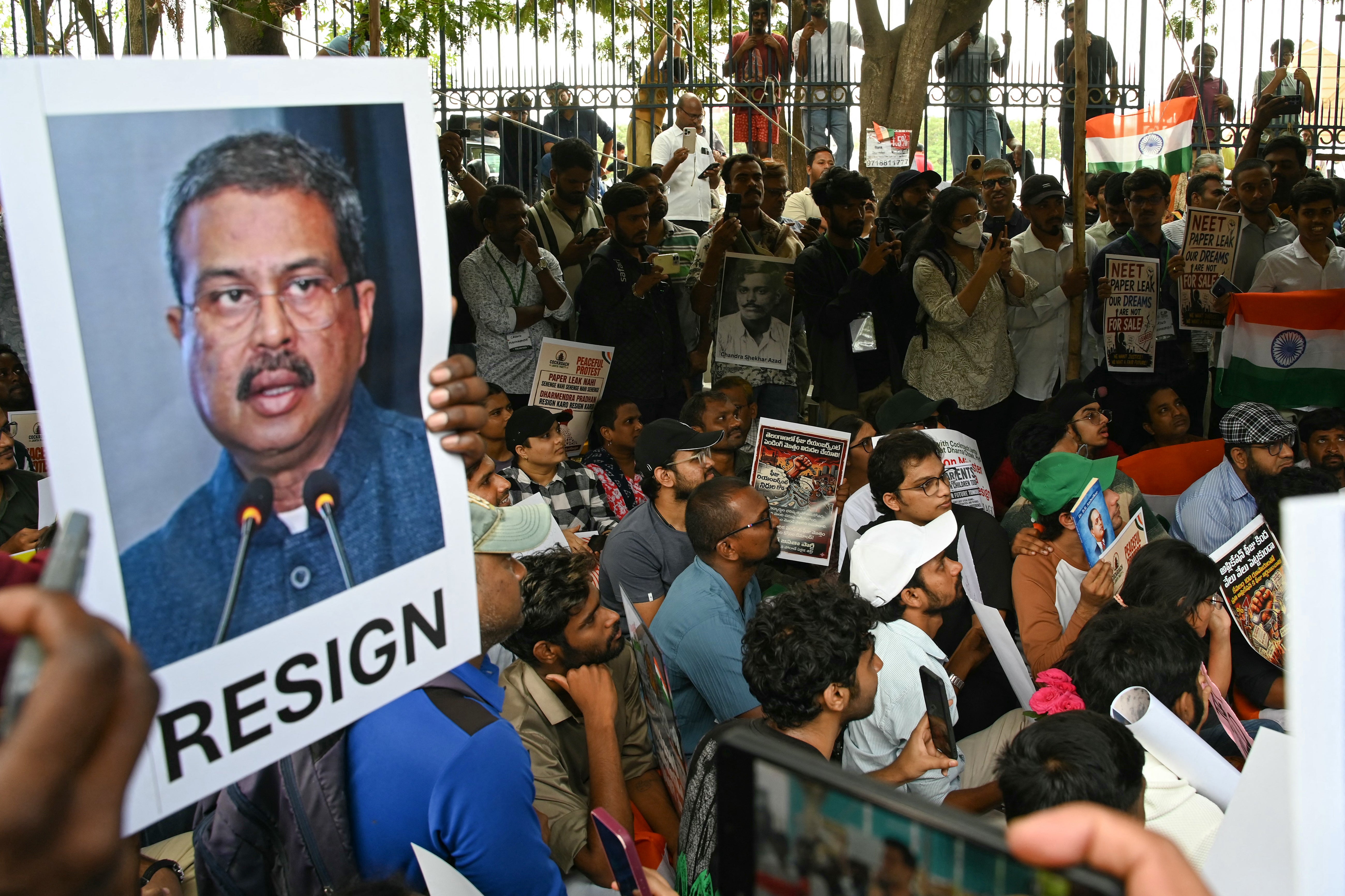 Cockroach Janata Party (CJP) activists a hold placard featuring India's Education Minister Dharmendra Pradhan during a protest over alleged irregularities in the country's major examinations in Hyderabad on June 14, 2026