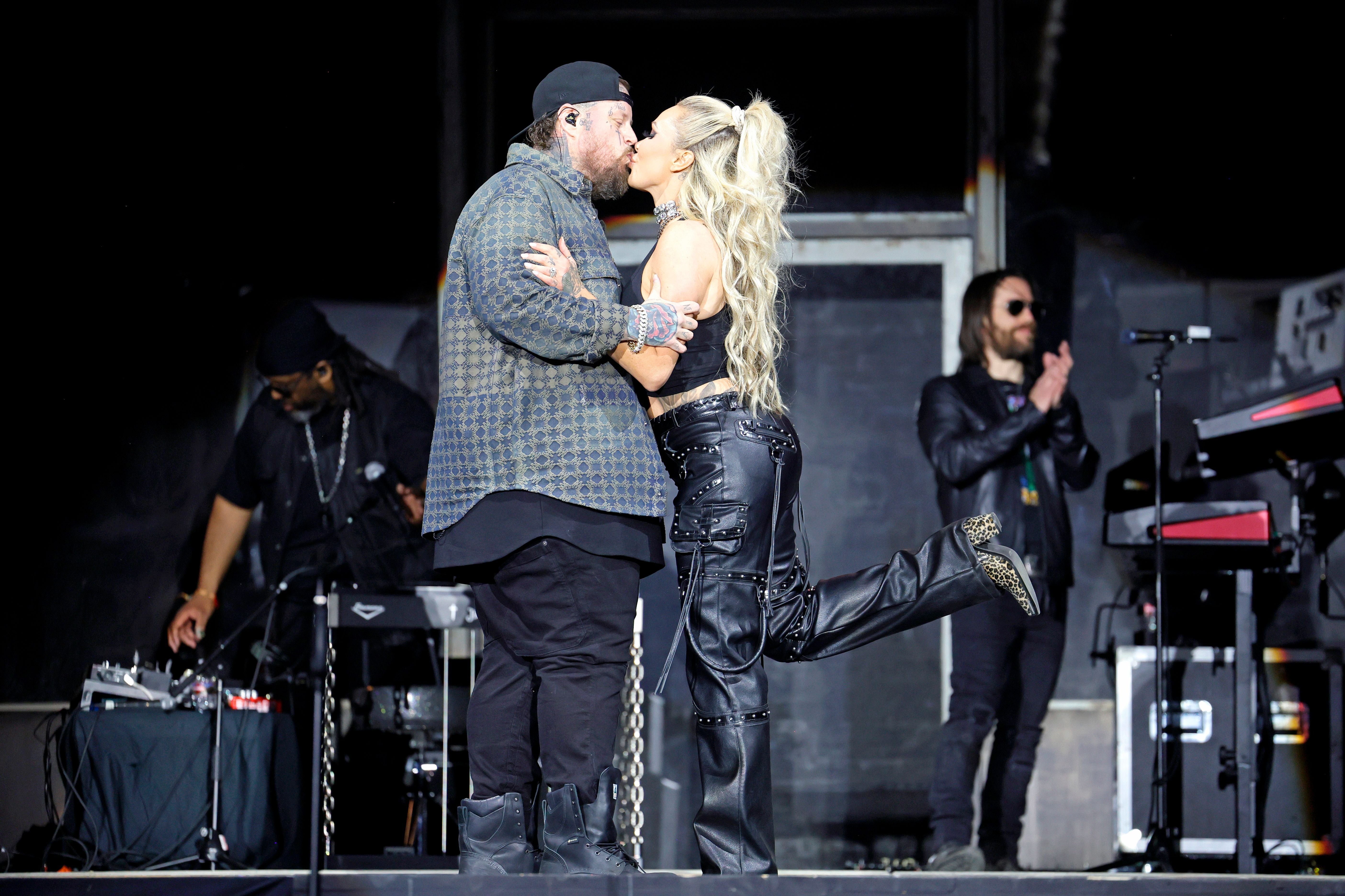 Jelly Roll and Bunnie Xo kissing onstage at a festival in 2025