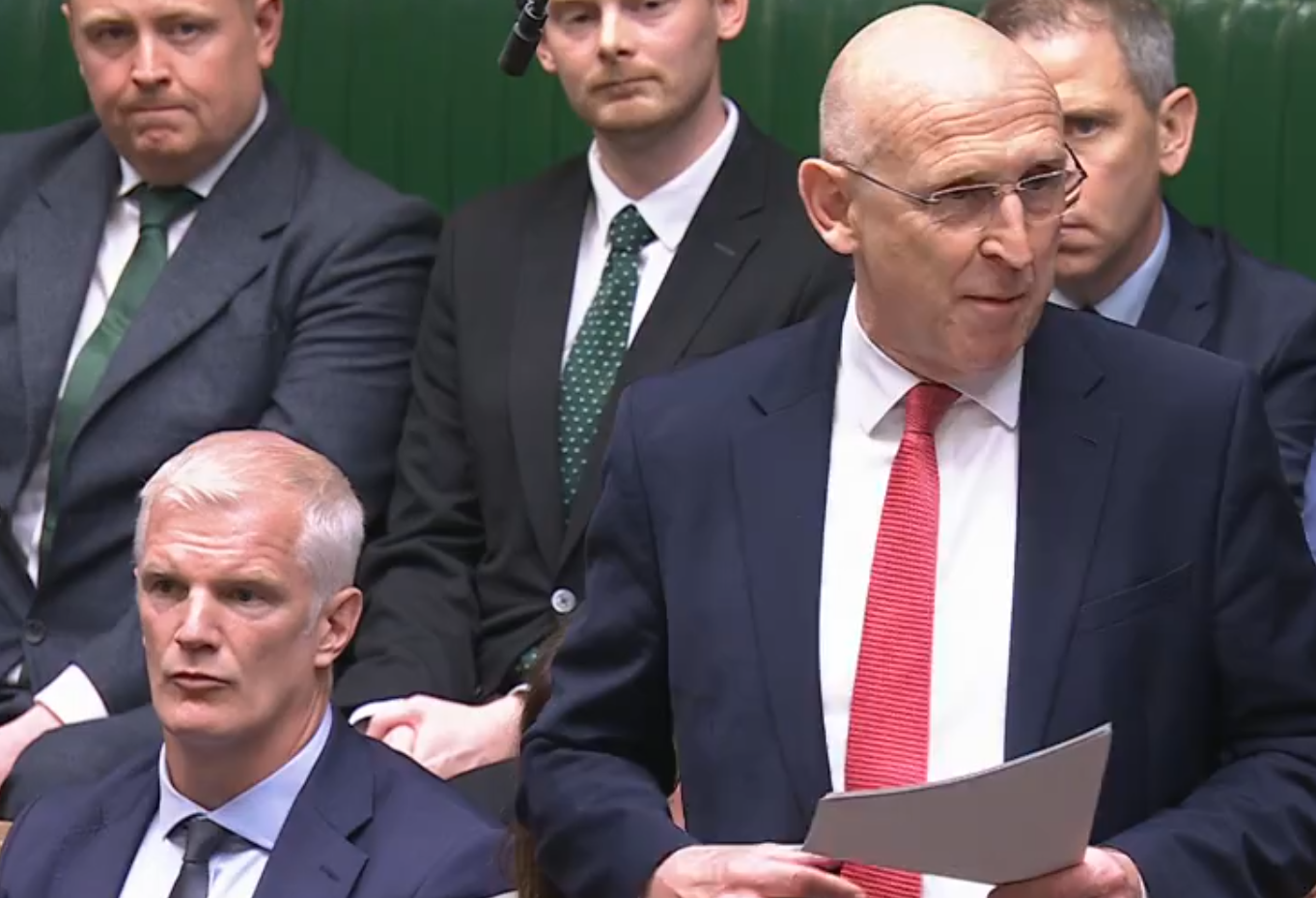 Healey makes his statement with Al Carns sitting next to him