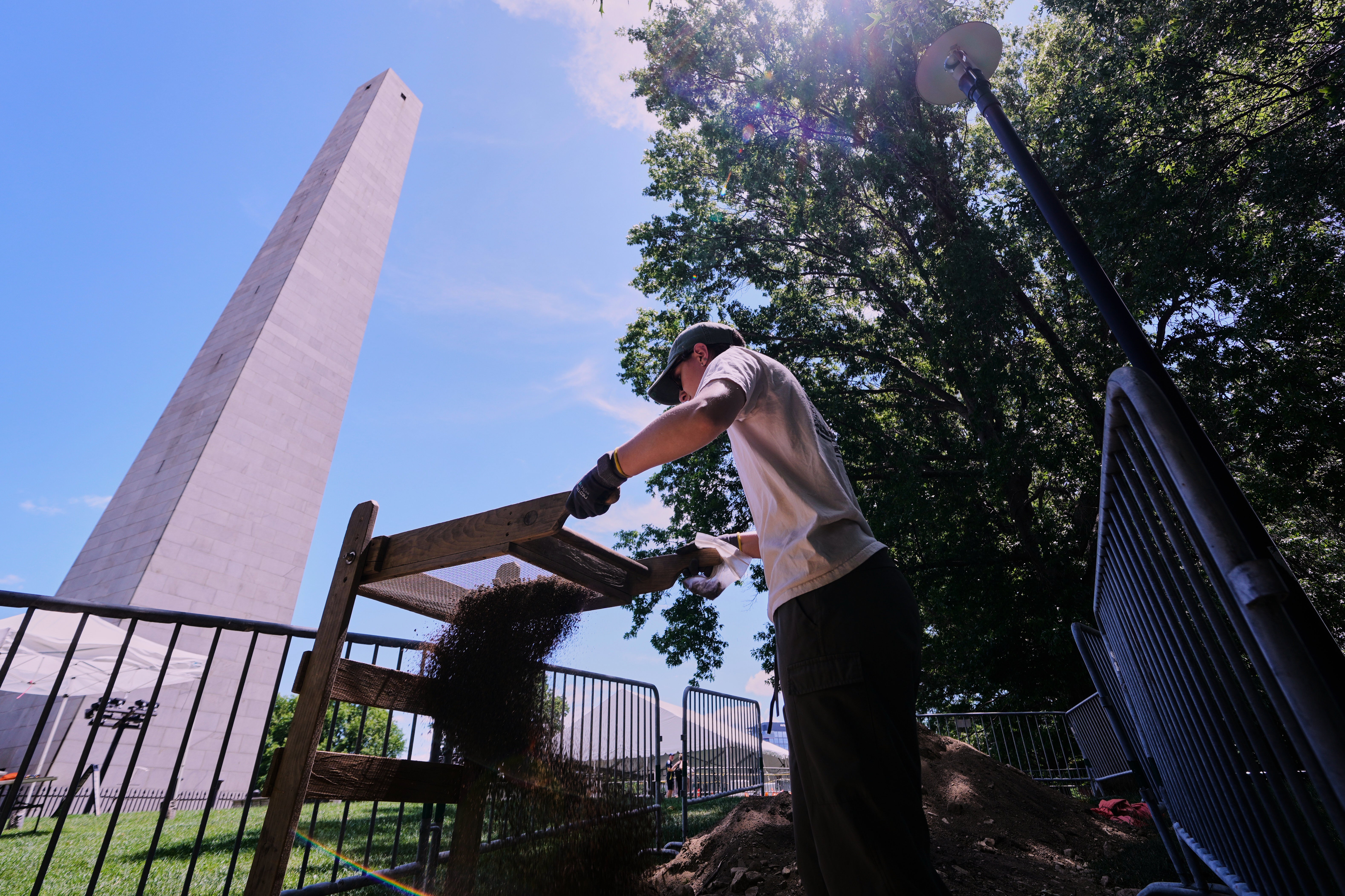 Calla Ruff, an intern from Carleton College, sifts dirt removed from an archaeological dig at the site