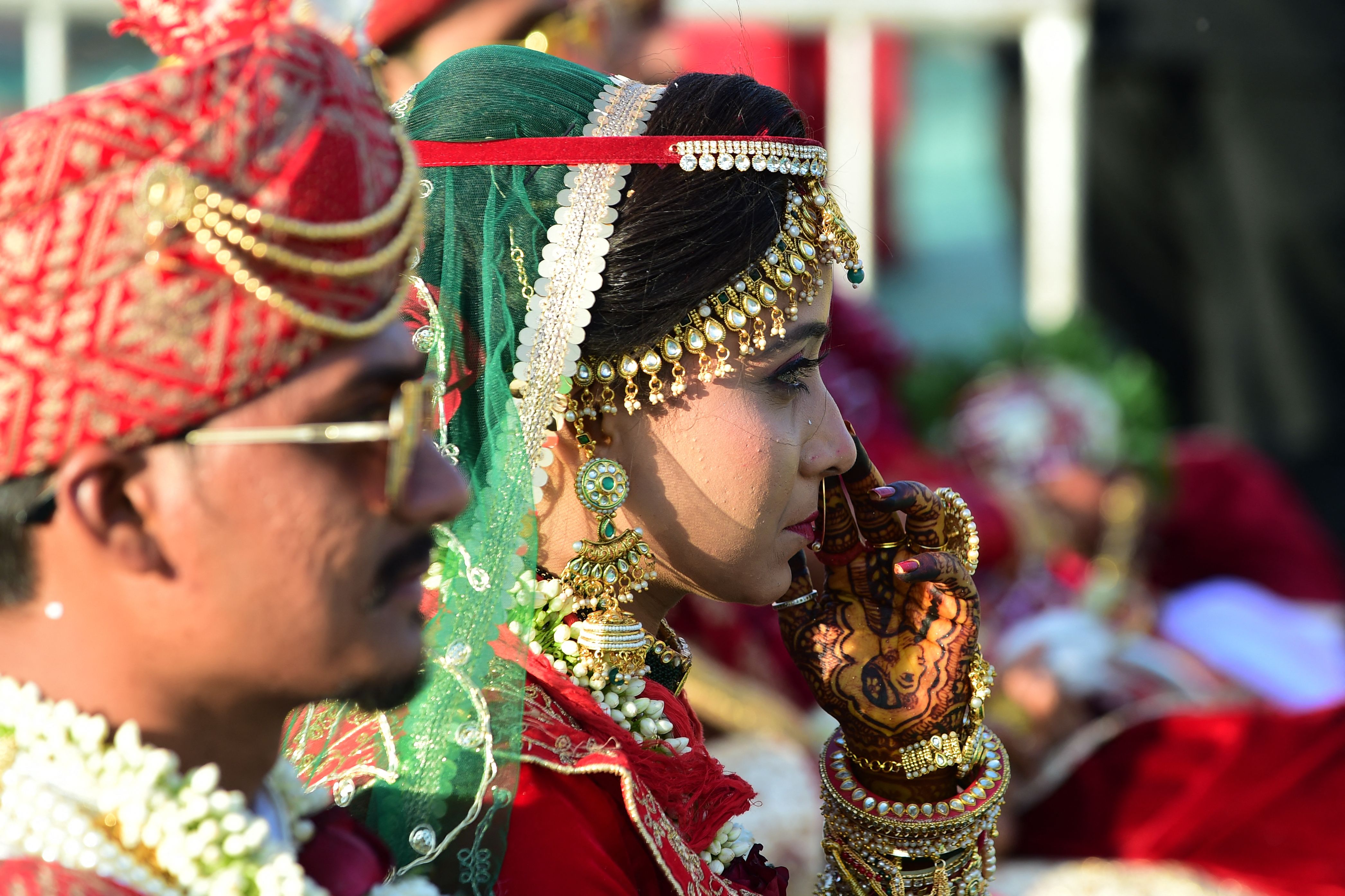 A newlywed couple looks on during the marriage of 20 Hindu couples in Ahmedabad on 11 February 2023