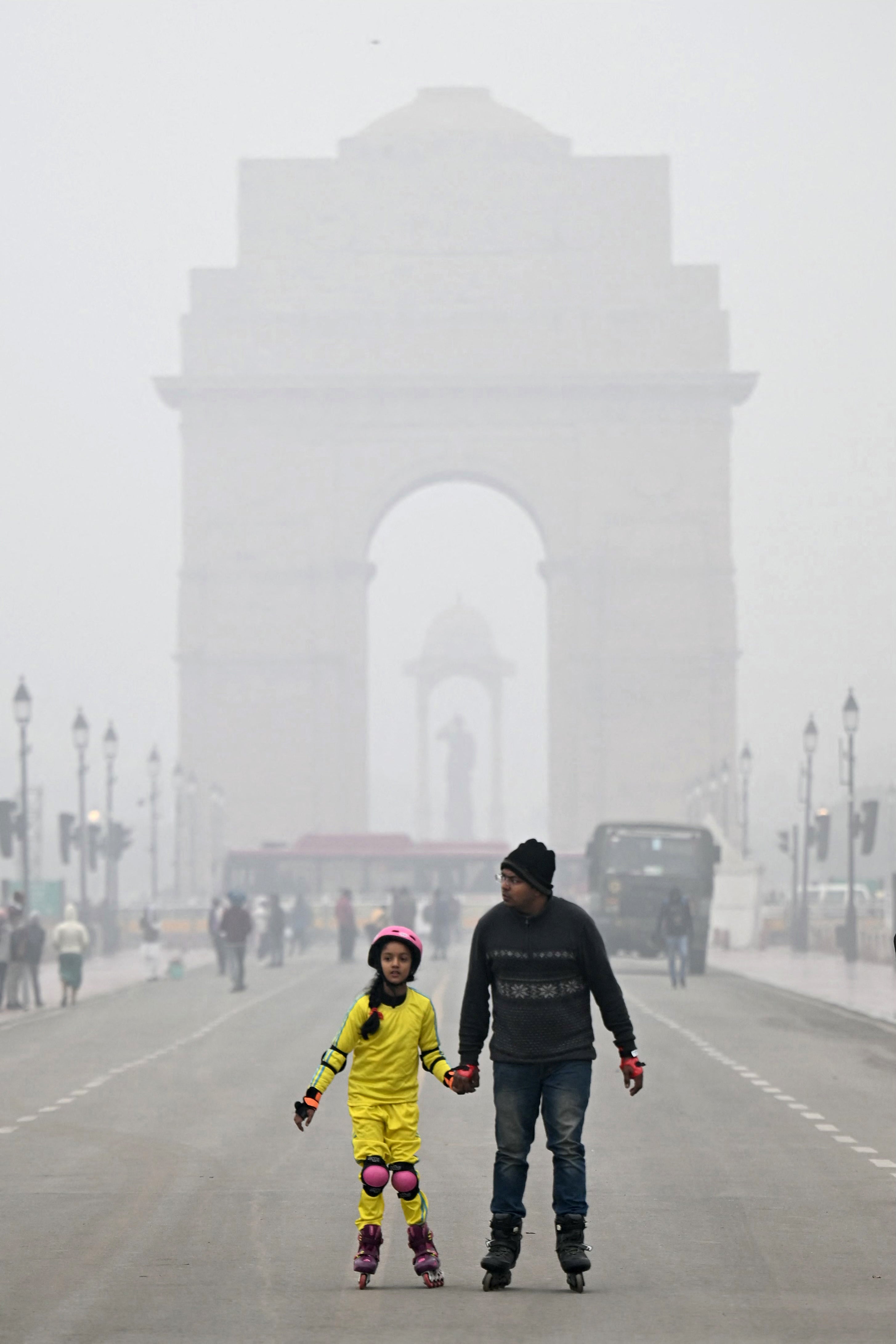 People skate in front of India Gate on a cold foggy winter morning in New Delhi on 3 January 2024