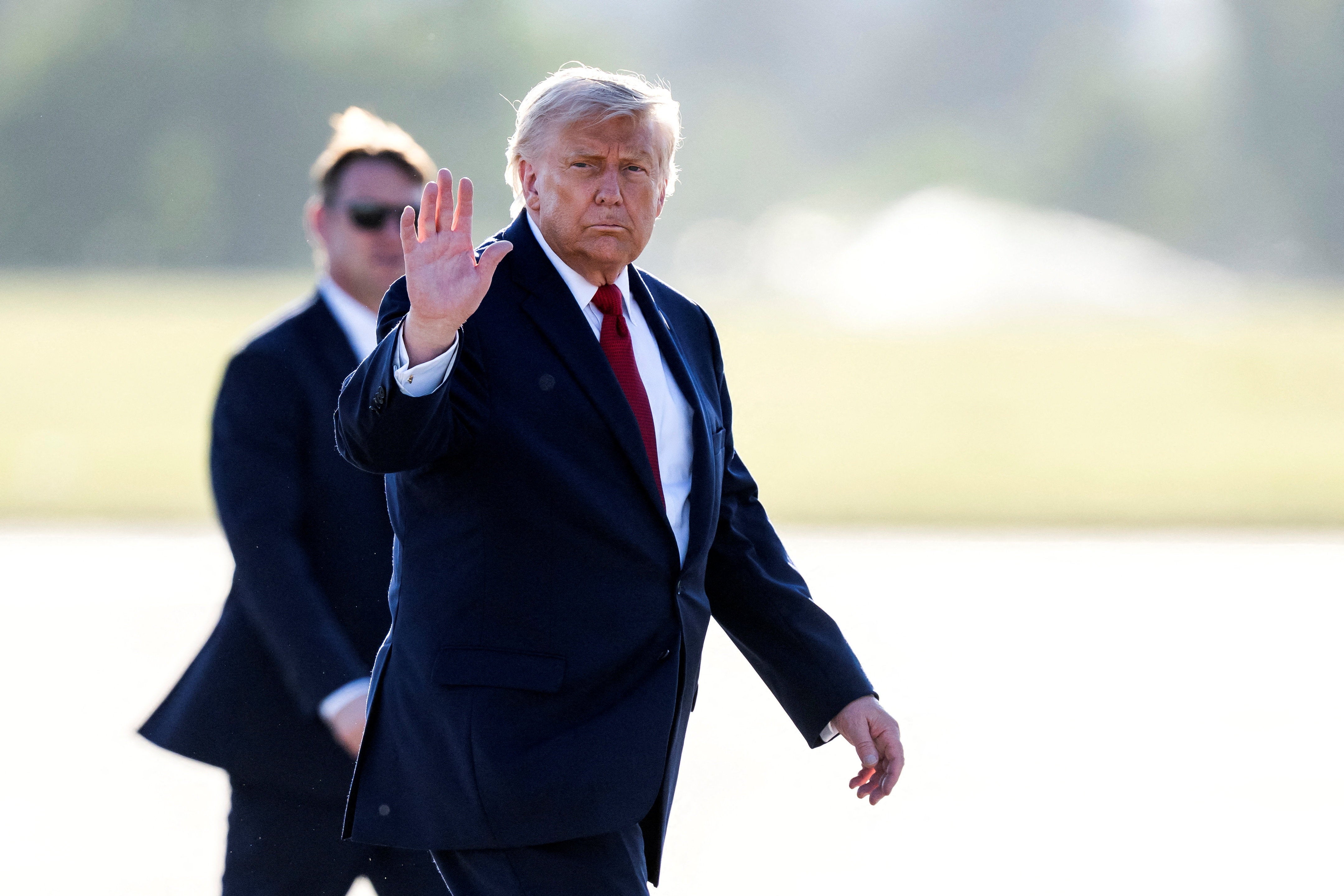 Trump gestures as he walks to board Air Force One at Geneva Airport following the G7 summit