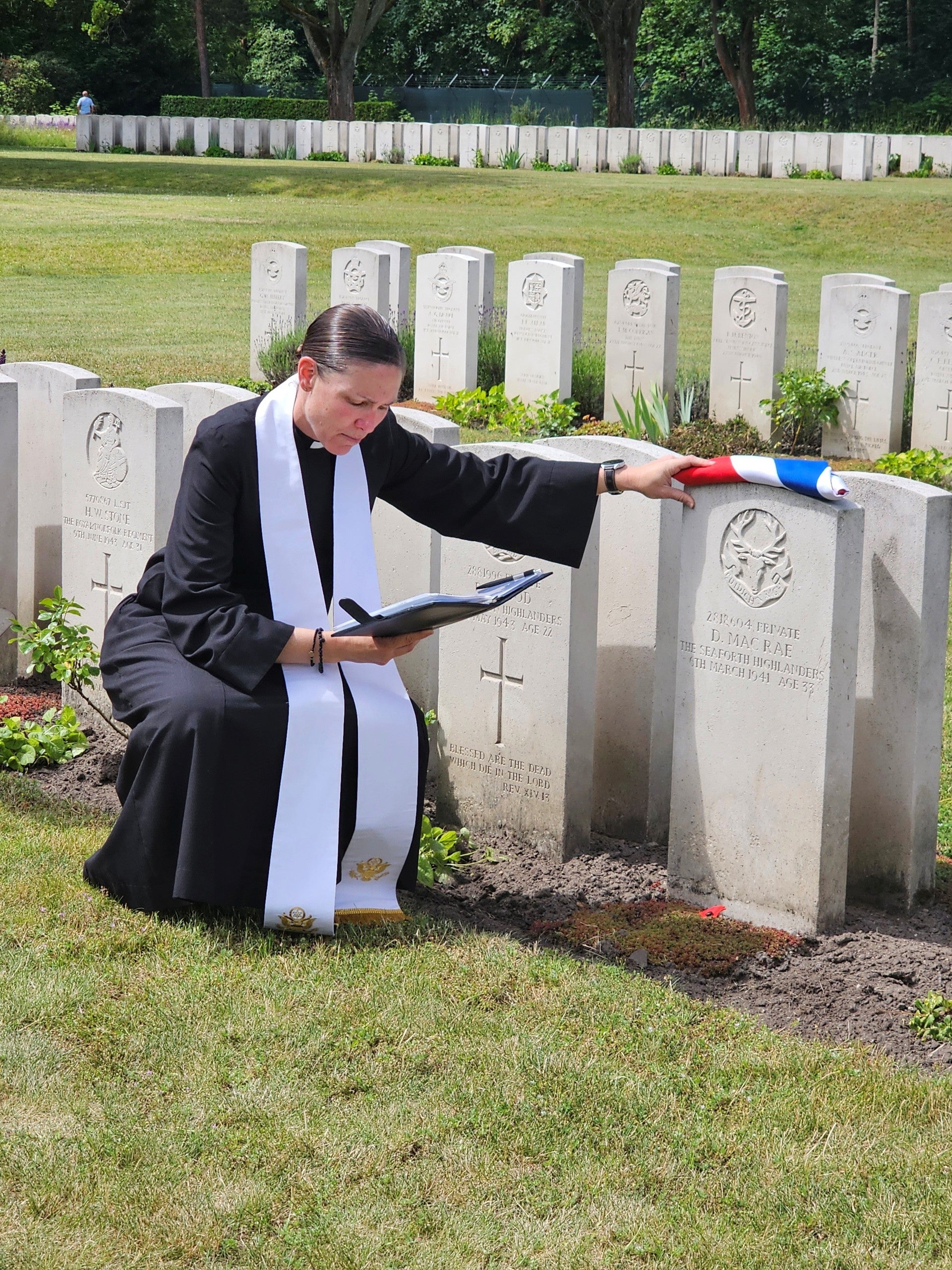Father Tiann Morgner blesses Donnie MacRae's grave