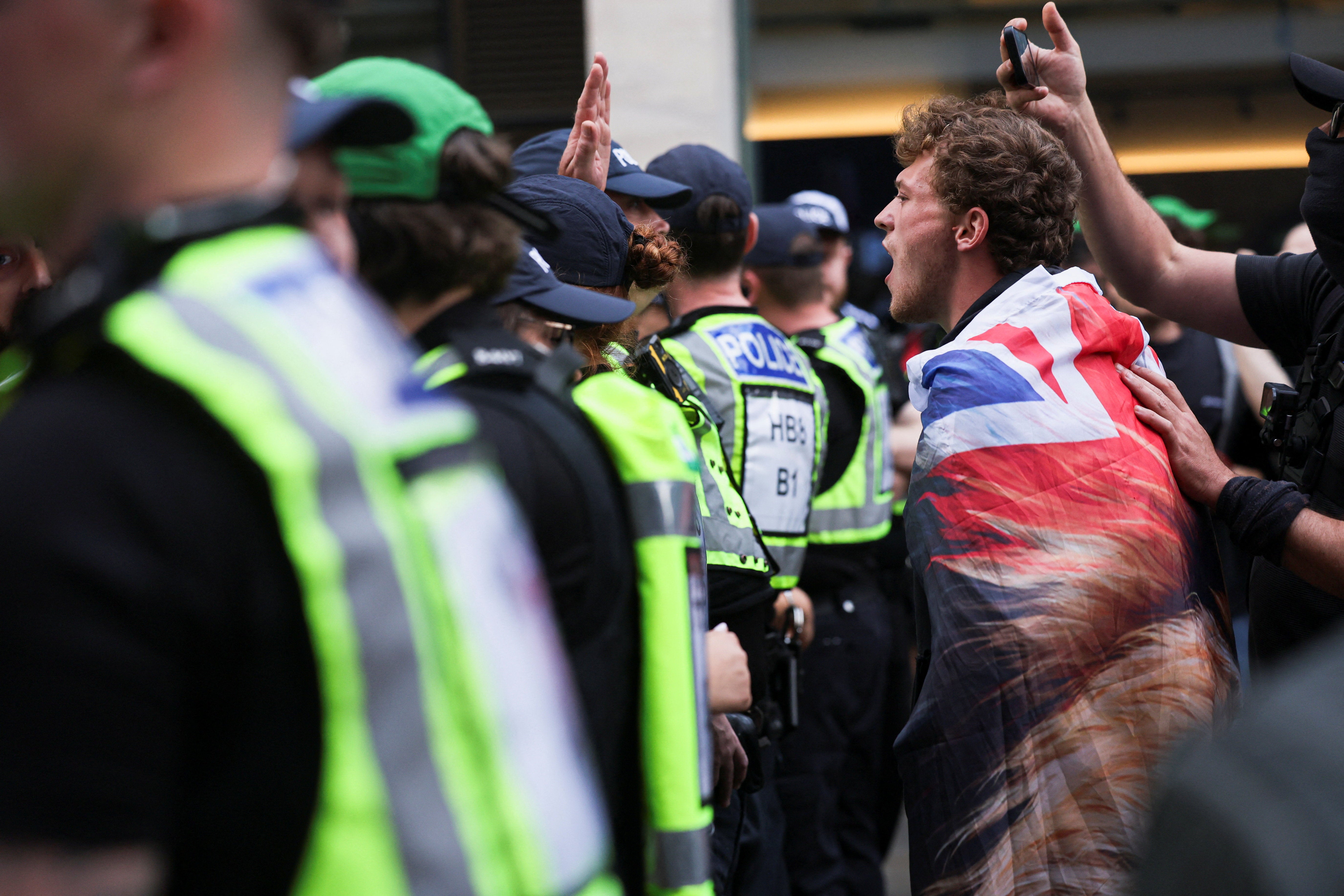 A counterprotester shouts over a line of police officers during the ‘All Out Against Tommy Robinson’ protest