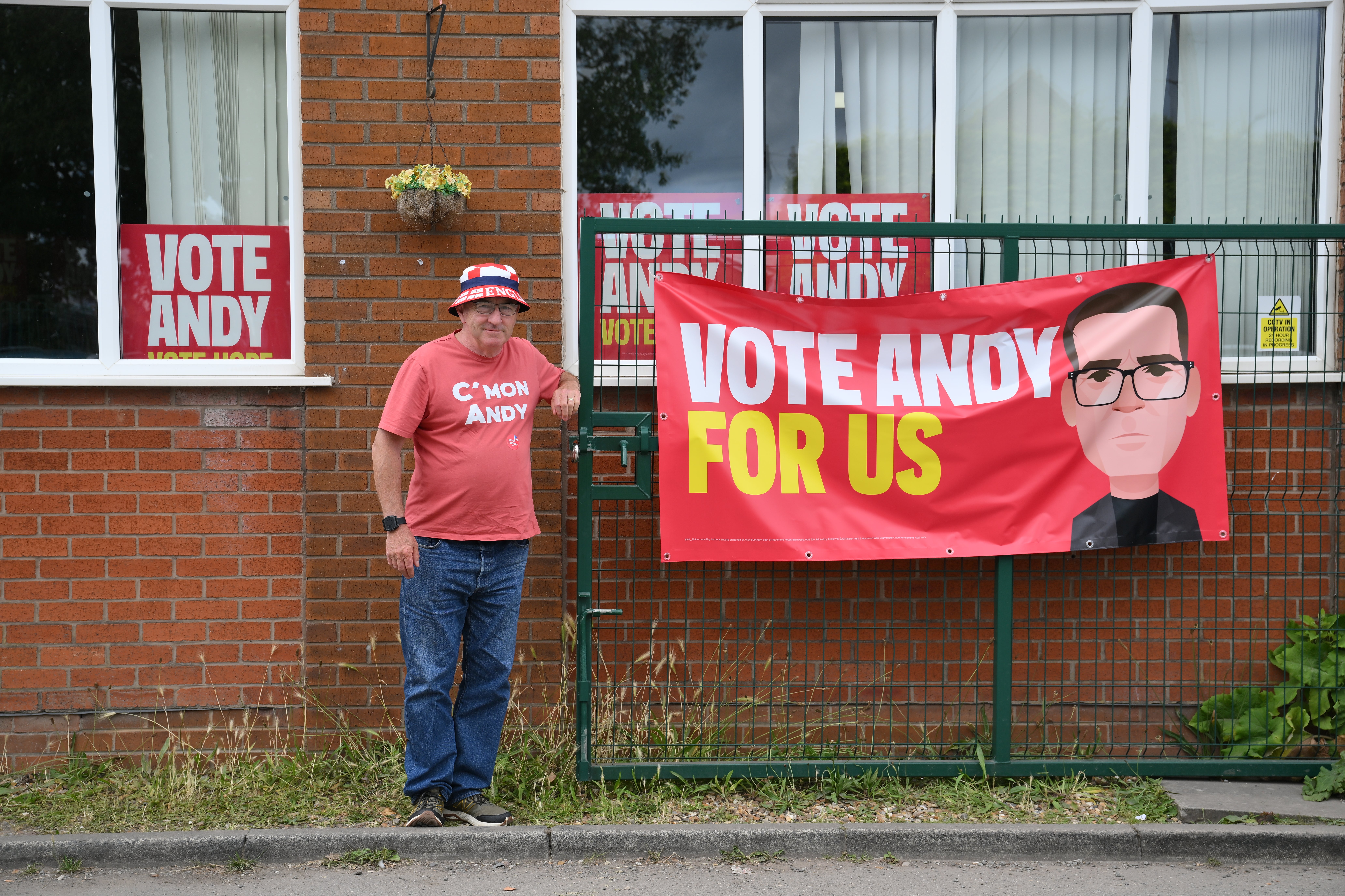 A Burnham supporter next to a banner at the Community Sports Club in Makerfield, Greater Manchester (PA)