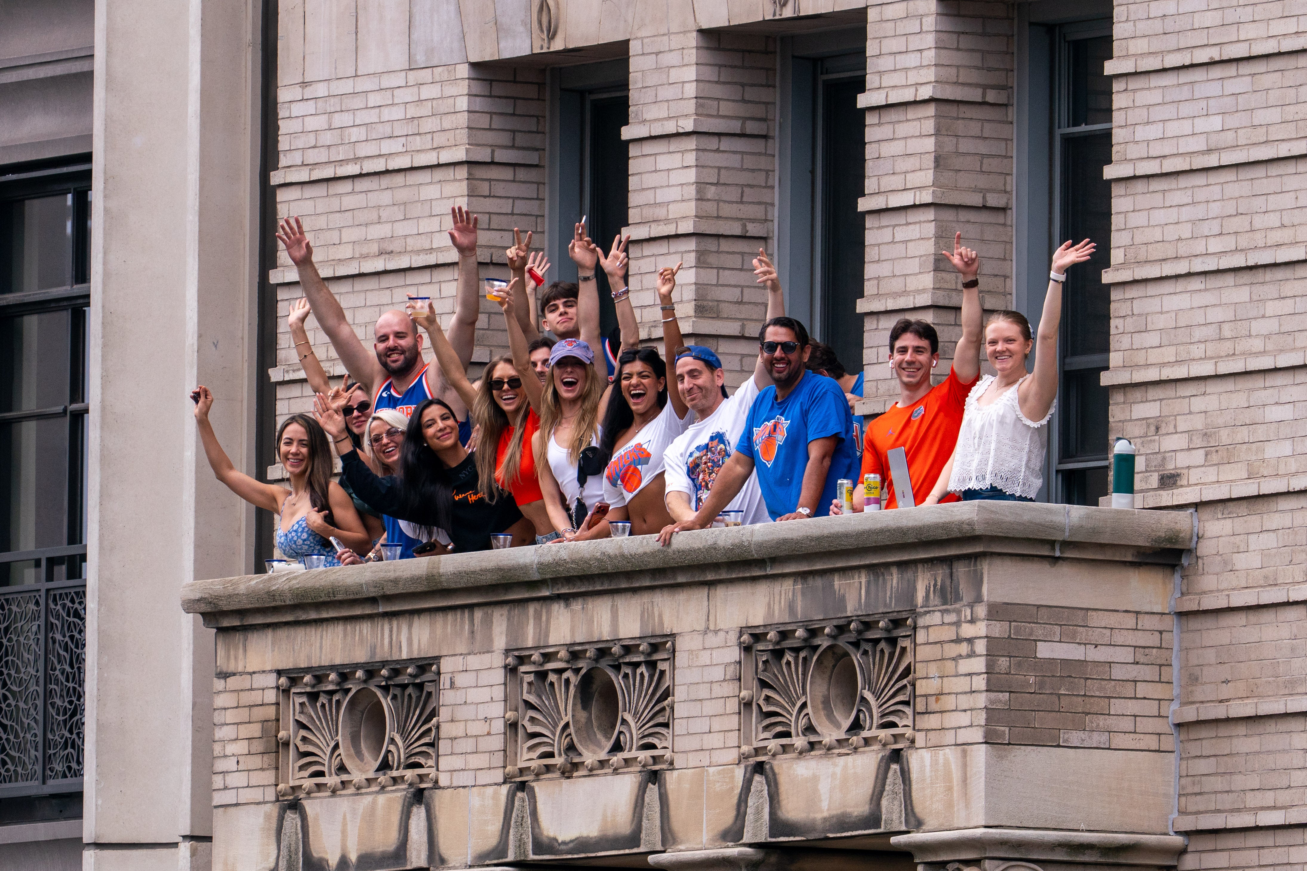 Revelers enjoy the parade from a balcony along the route