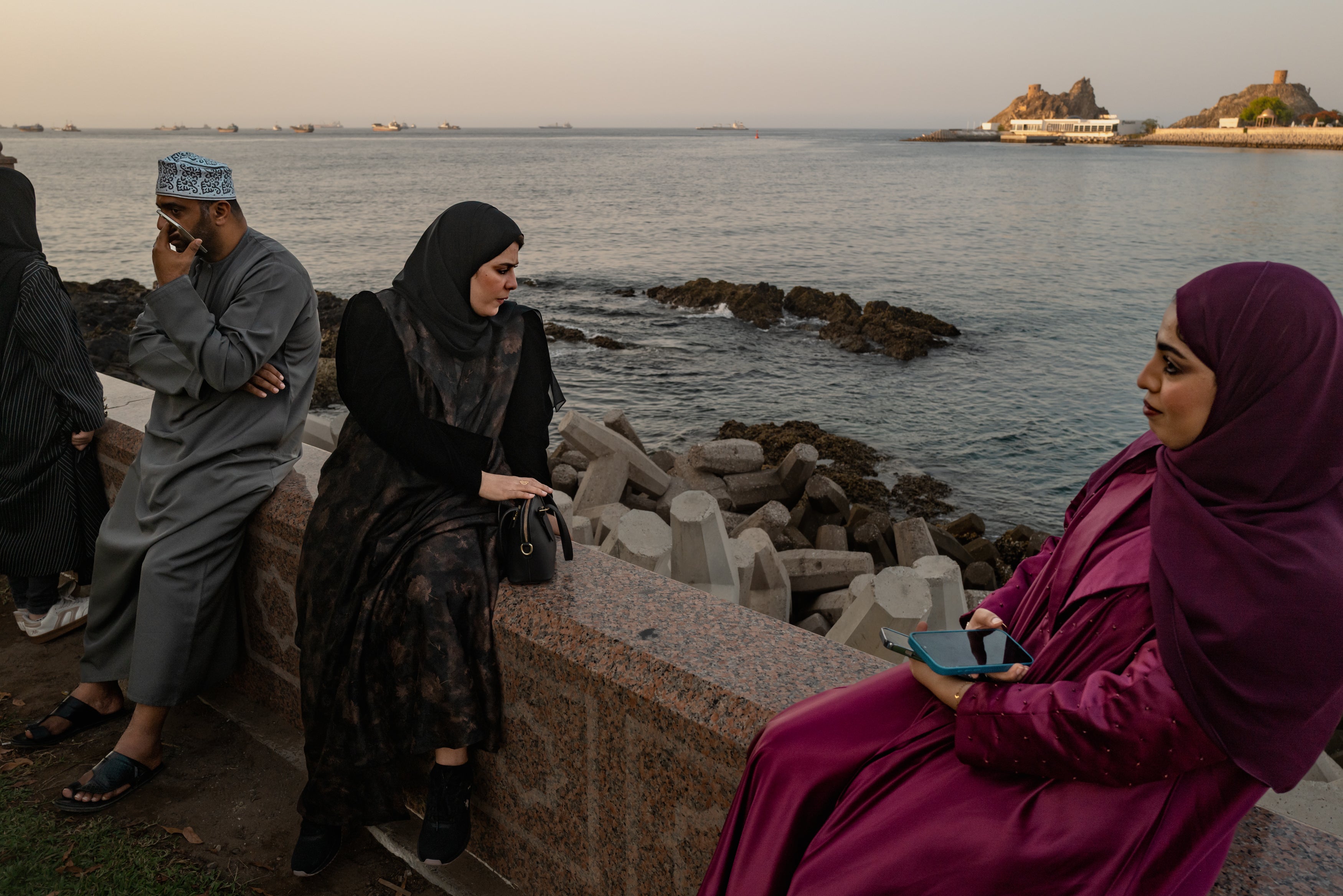 A family spends time together as oil tankers, general cargo ships, bulk carriers, and fishing boats sit anchored in the waters off Muscat near the Strait of Hormuz on Thursday in Muscat, Oman (Getty Images)