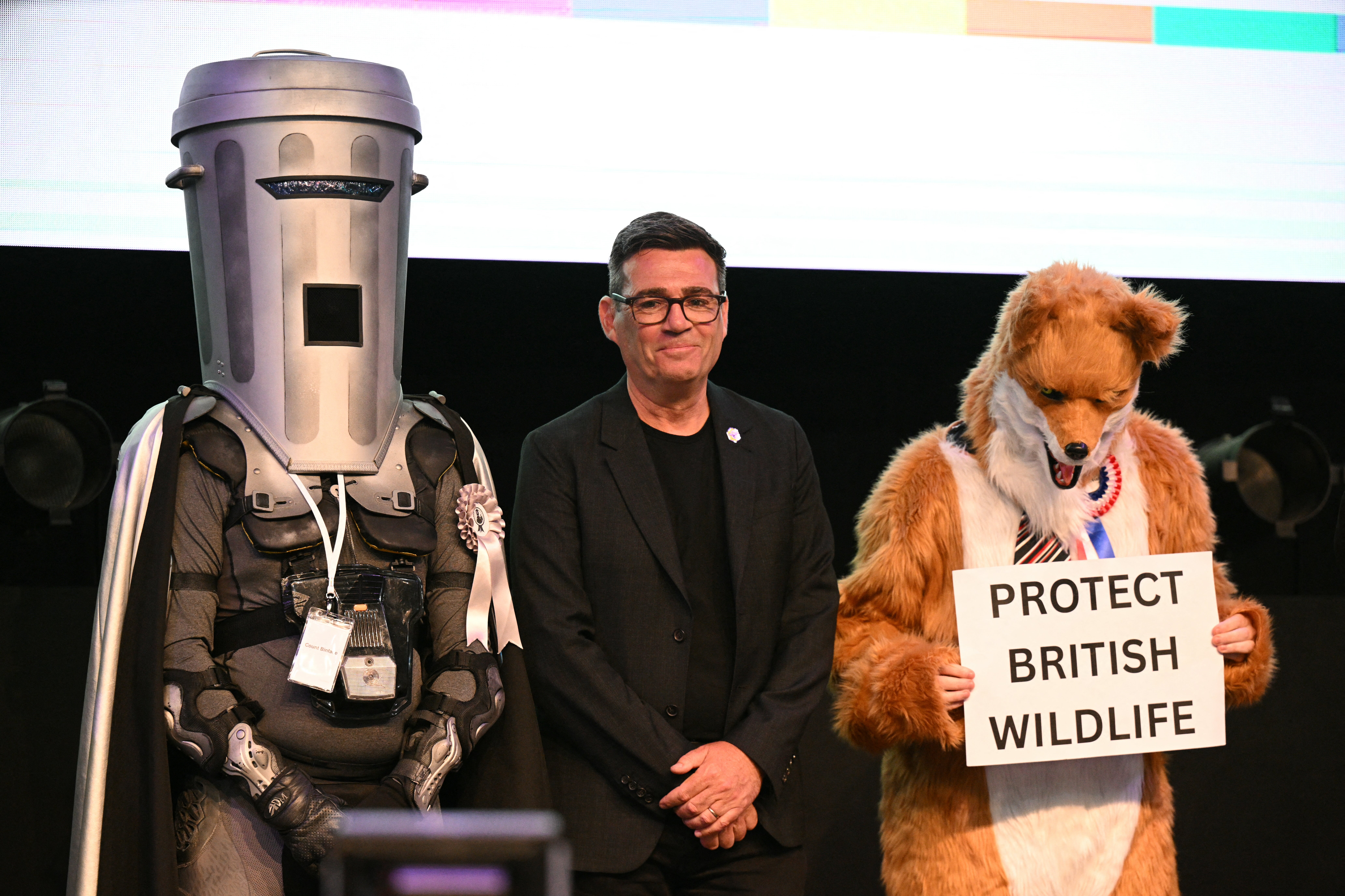 Andy Burnham stands between fellow Makerfield candidates Count Binface (L) and Robert Pownall (R)
