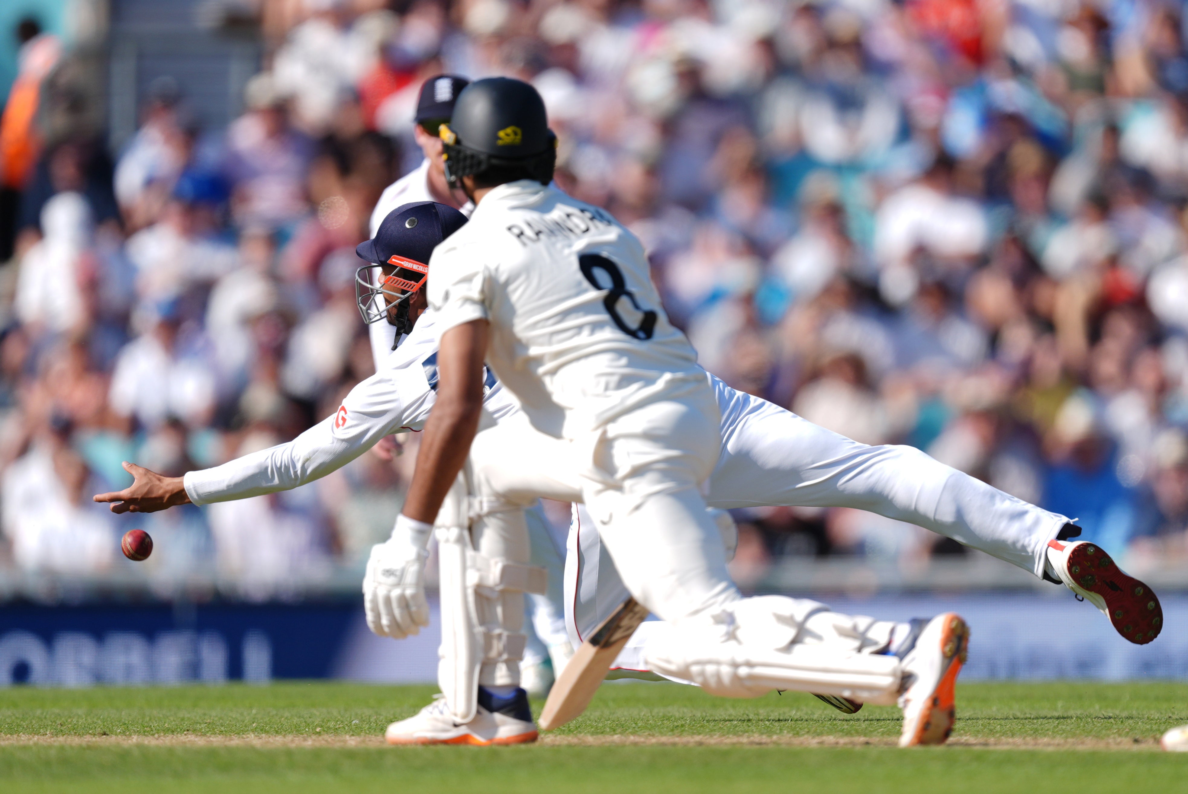 Emilio Gay dives but fails to take the catch off New Zealand’s Rachin Ravindra (foreground)