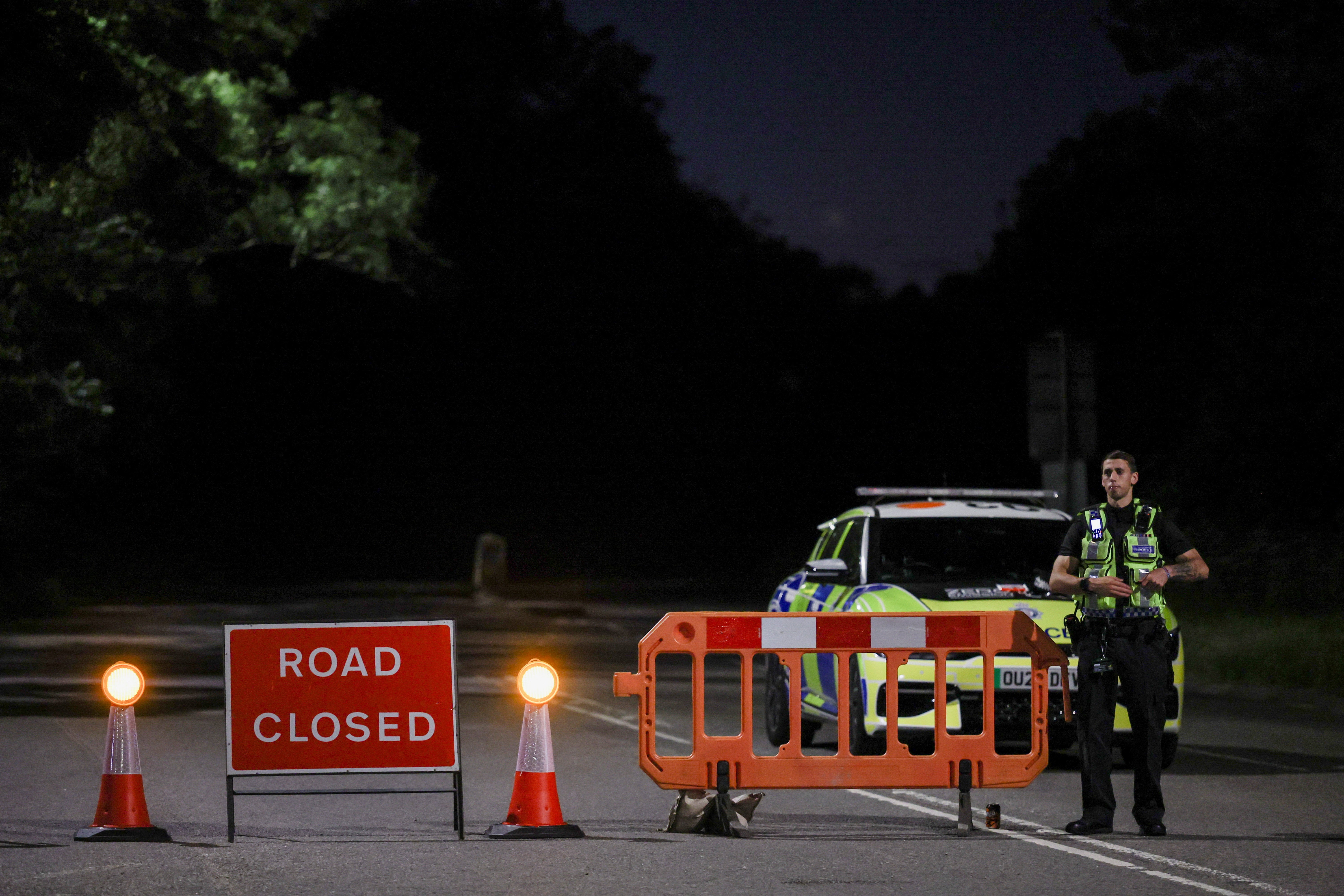 Police block a road that gives access into an area near the scene of a collision involving two trains near Bedford, Britain