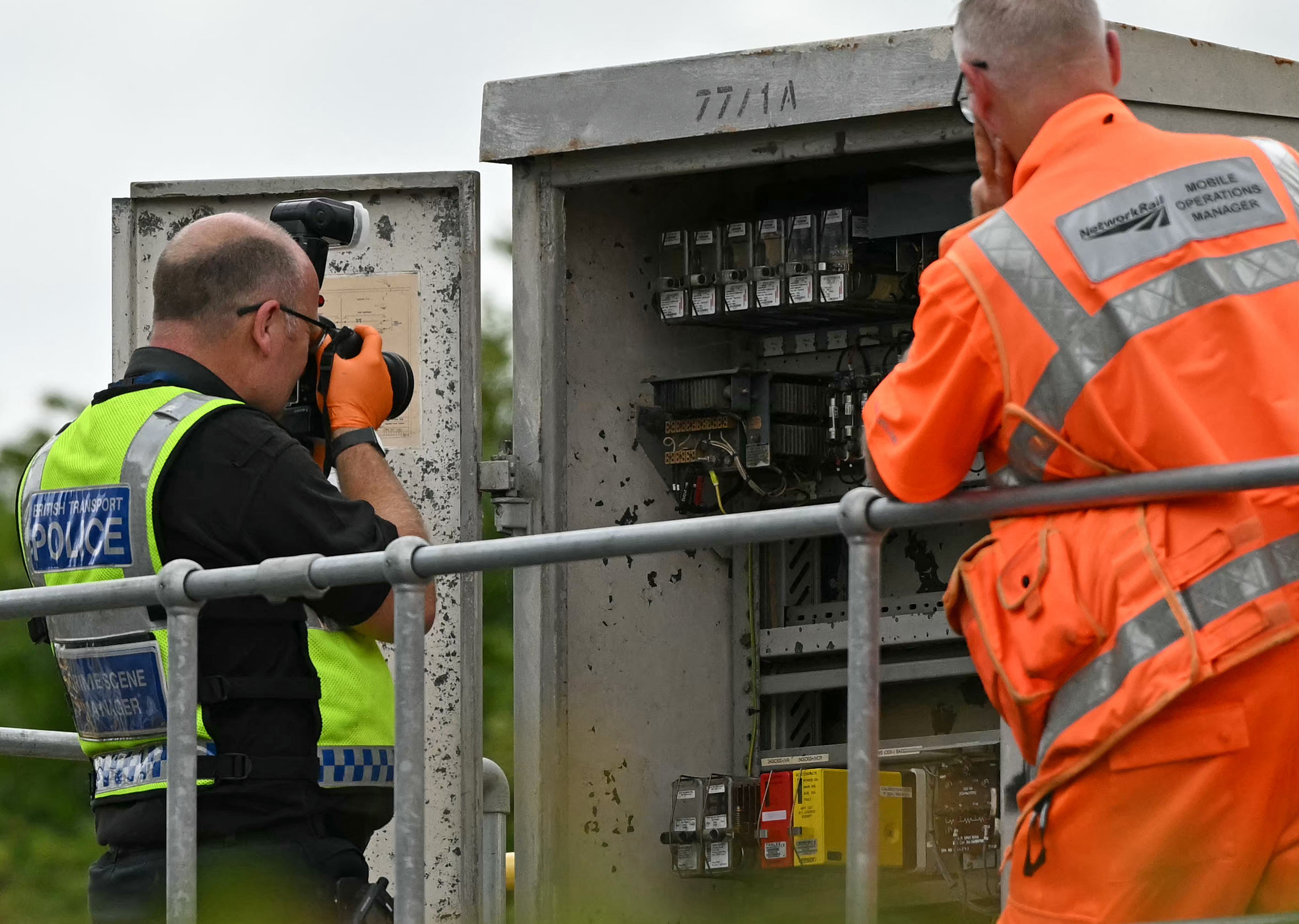 A Crime Scene Manager from the British Transport Police photographs the inside of an trackside Location Case (LOC), commonly used to house signalling equipment