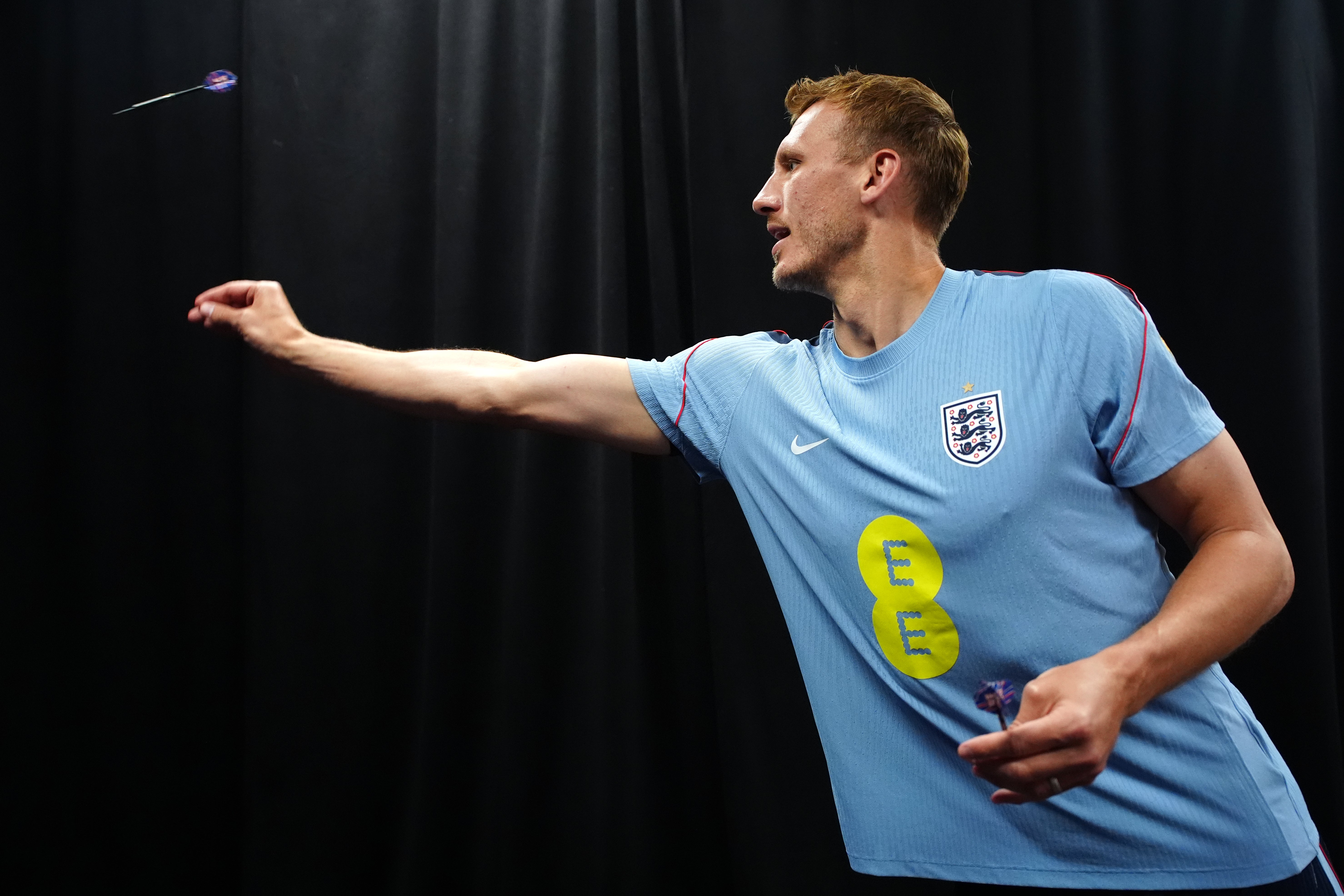 England's Dan Burn plays darts during a press conference