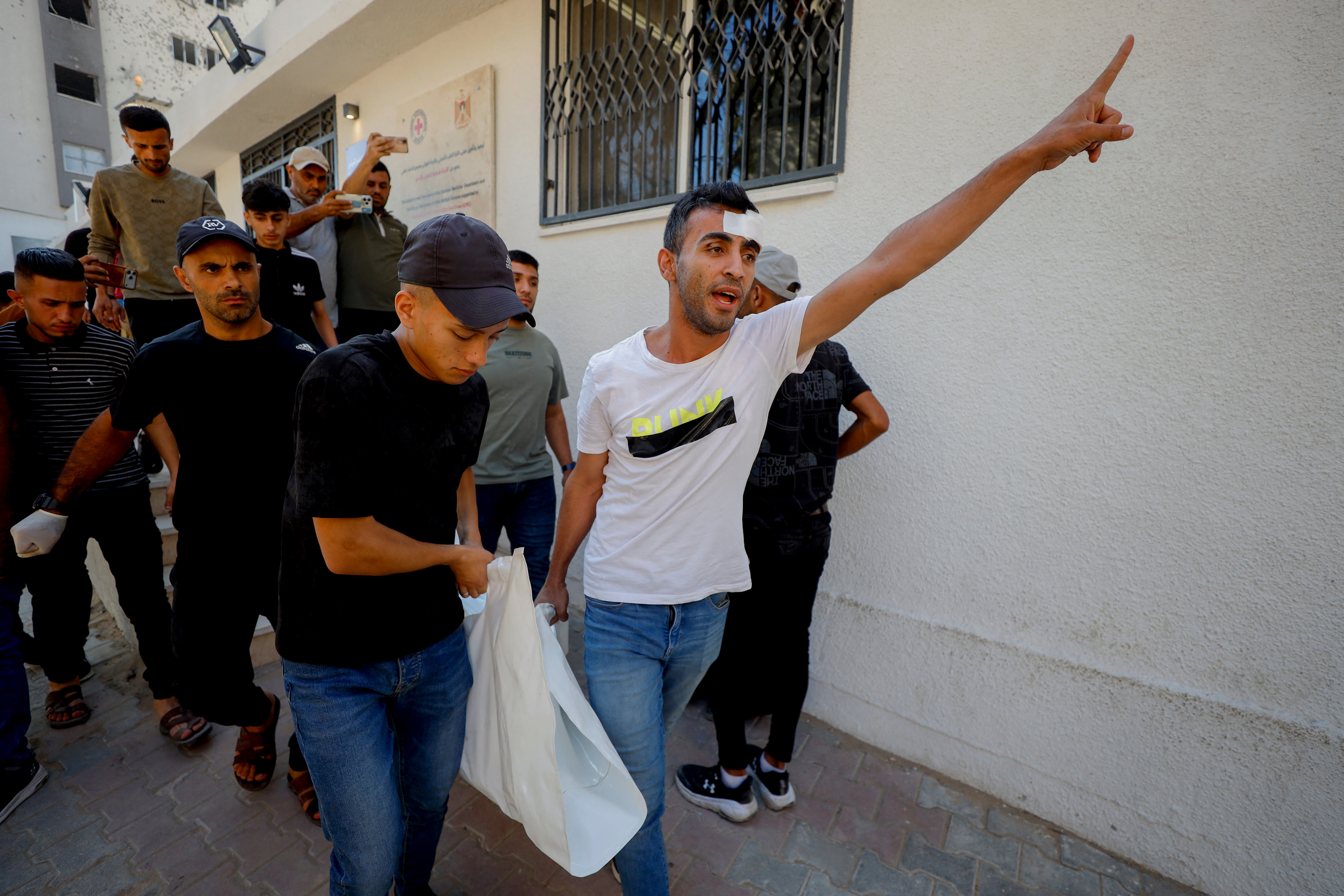 Palestinians carry a shrouded body following an Israeli strike on the Al-Maghrebi area in Gaza City (AFP/Getty)