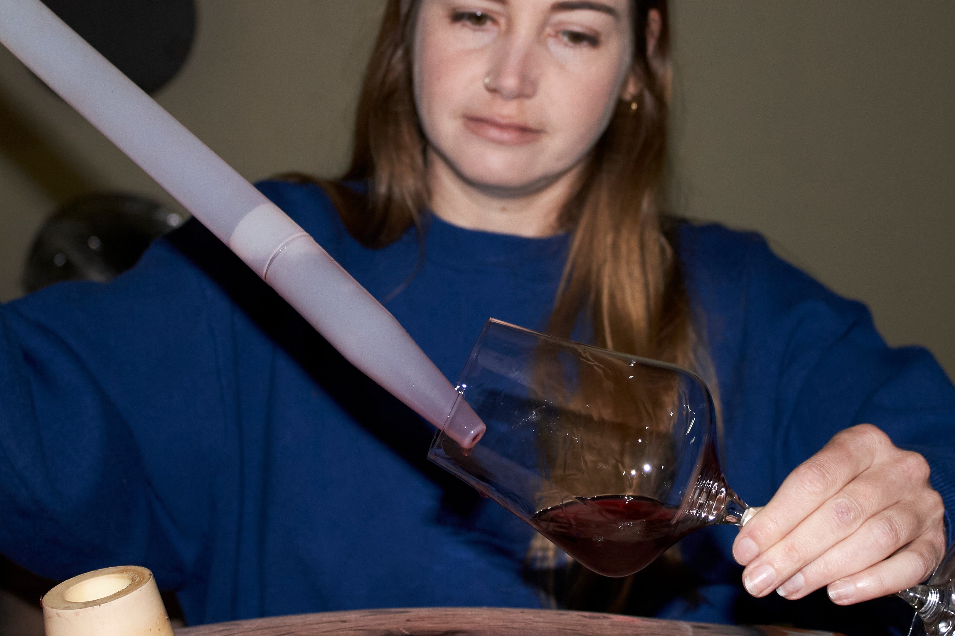 Natasha Jacka pours wine from an oak barrel into a glass using a 