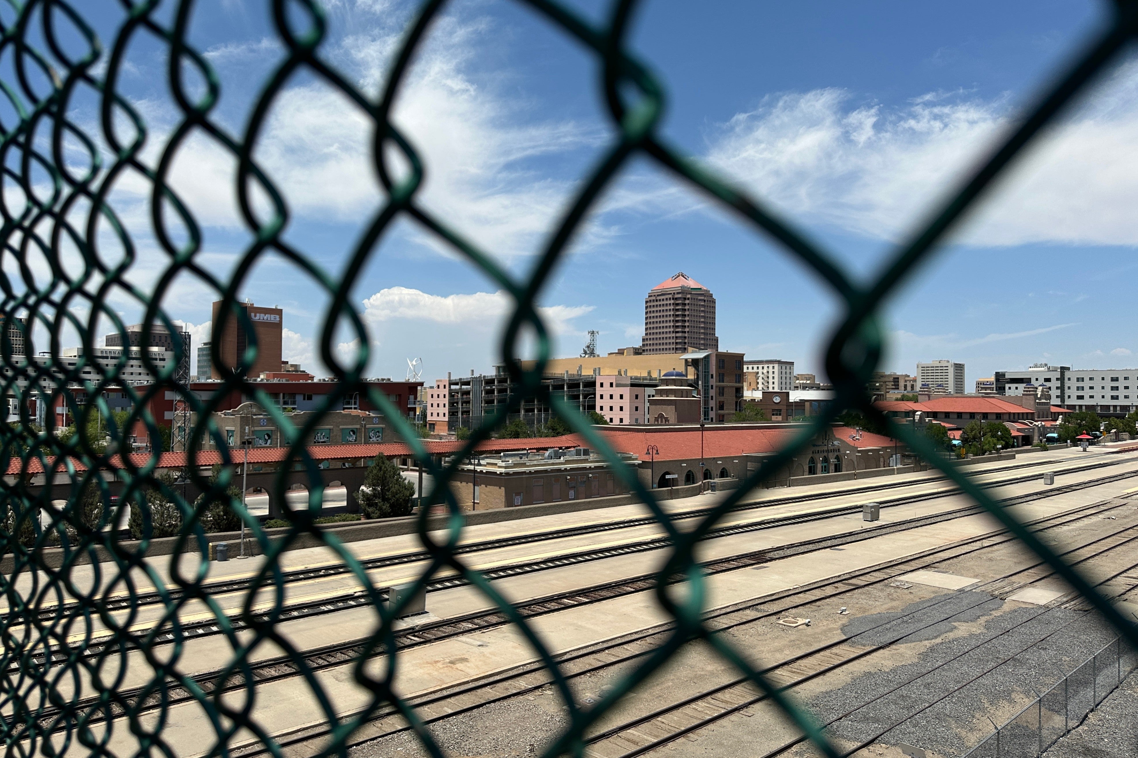 The tallest building in downtown Albuquerque, N.M., which houses the U.S. attorney's office, is seen beyond a chain link fence