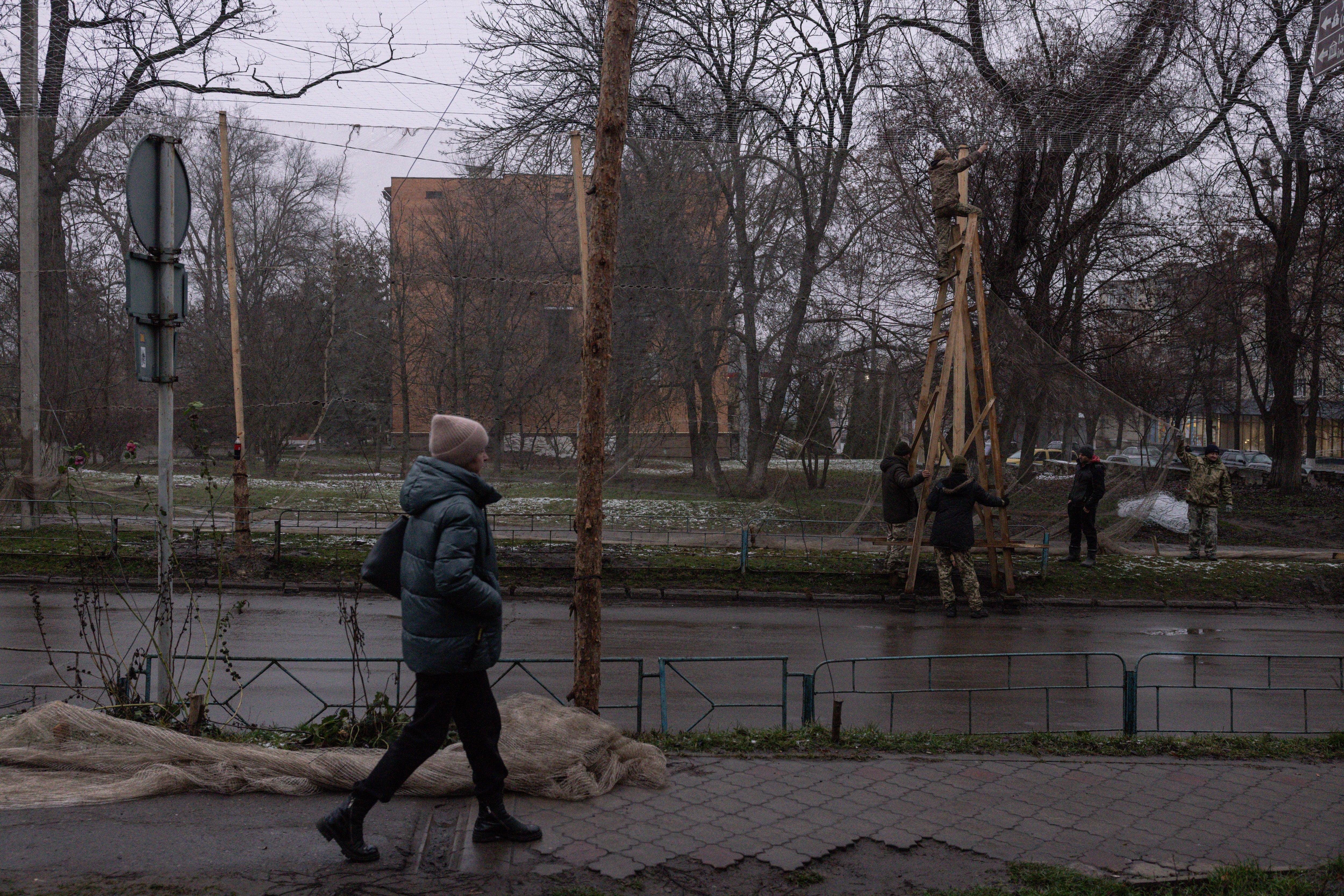 Members of the Ukranian Armed Forces install anti-drone nets in the city centre of Izyum on 10 December 2025 as people expect Russia to intensify its attacks as it advances in the Donbas region. (Getty)