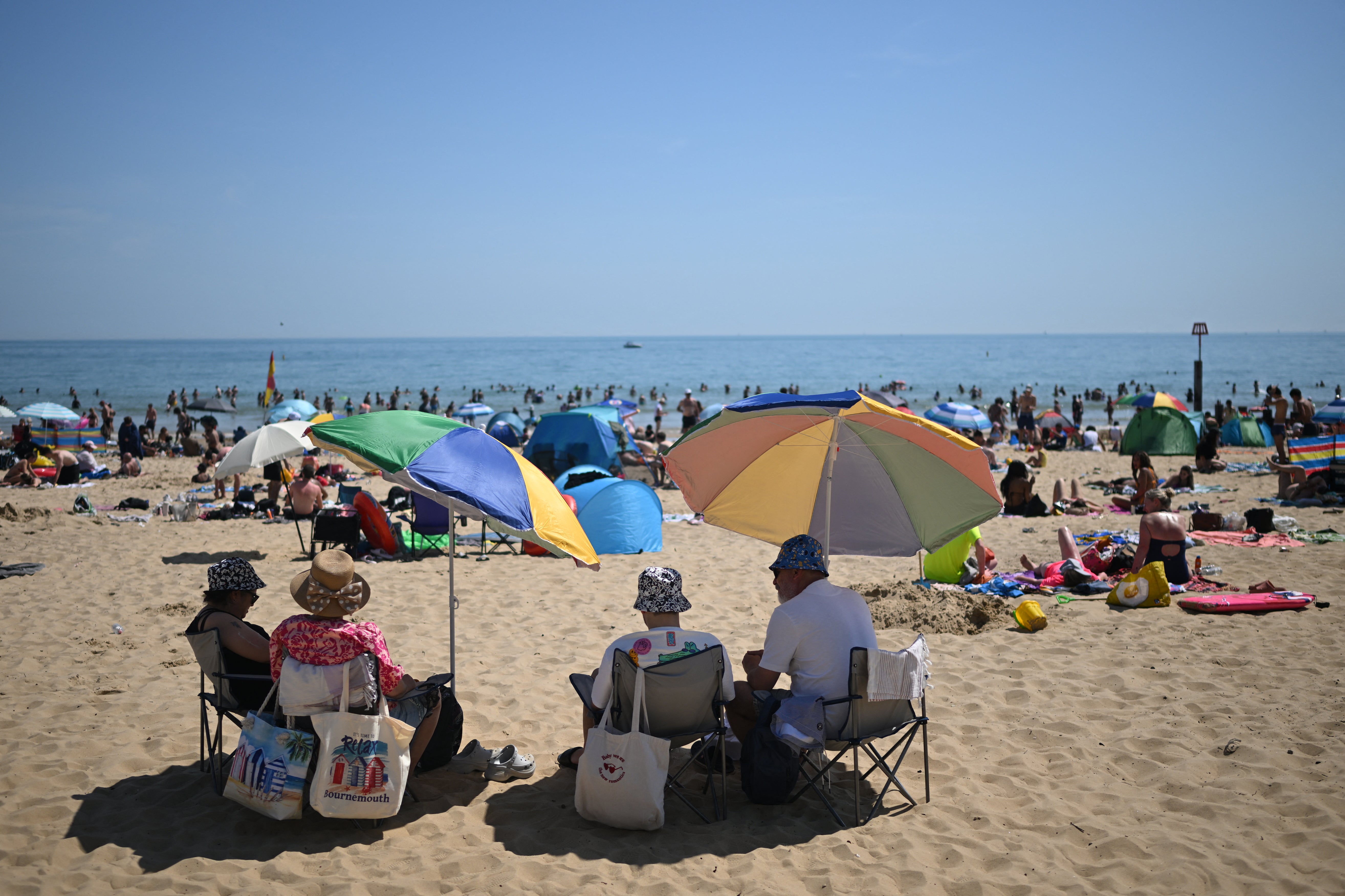 Sunbathers relax in the sunshine on Bournemouth beach on the south coast of England