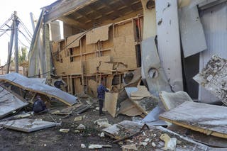 Employees remove debris at a compound of an agricultural enterprise hit by a Russian missile strike on Sunday evening, amid Russia's attack on Ukraine, in Odesa region