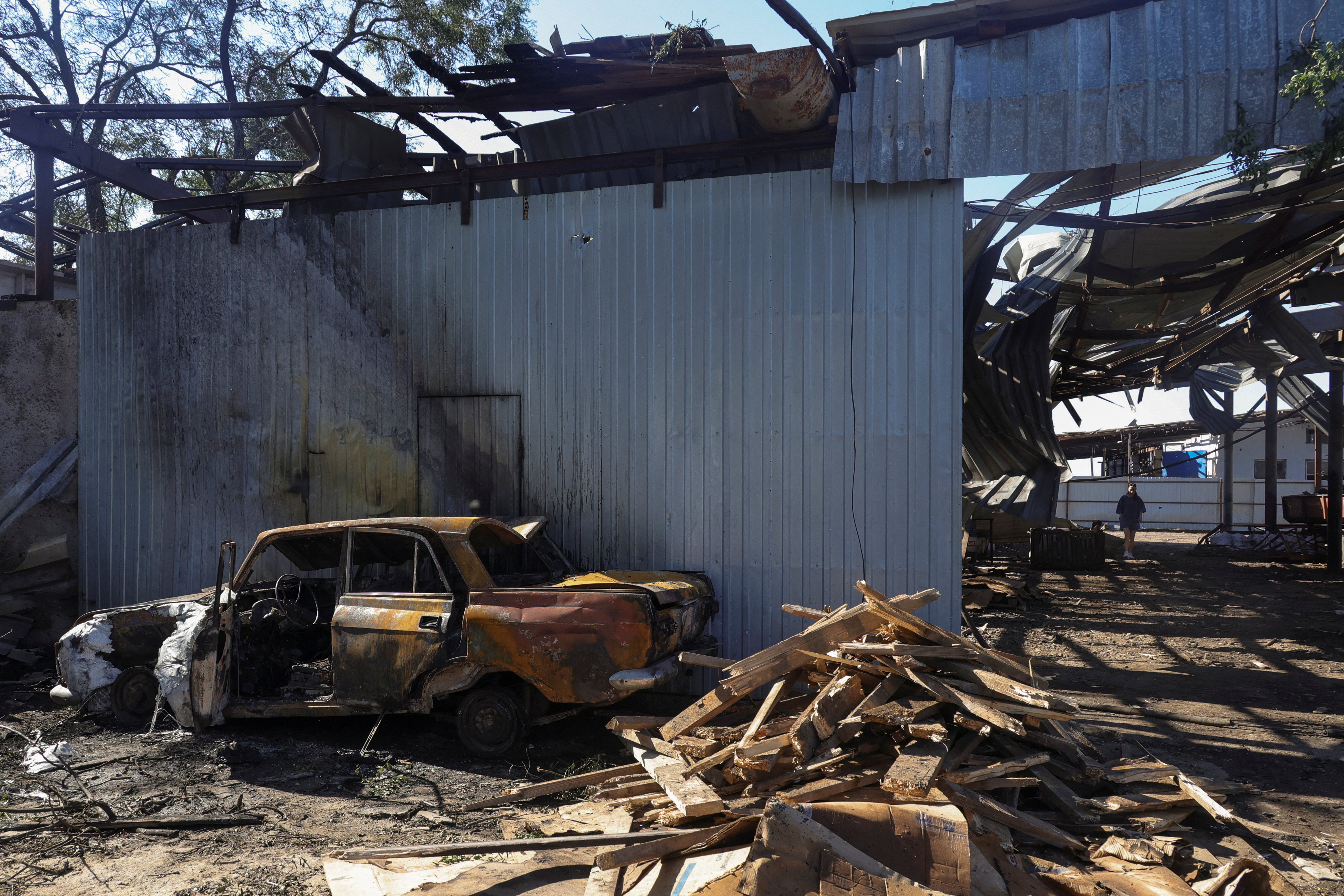 A woman walks at a compound of an agricultural enterprise hit by a Russian missile strike on Sunday evening, amid Russia's attack on Ukraine, in Odesa region (Reuters)