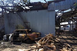 A woman walks at a compound of an agricultural enterprise hit by a Russian missile strike on Sunday evening, amid Russia's attack on Ukraine, in Odesa region