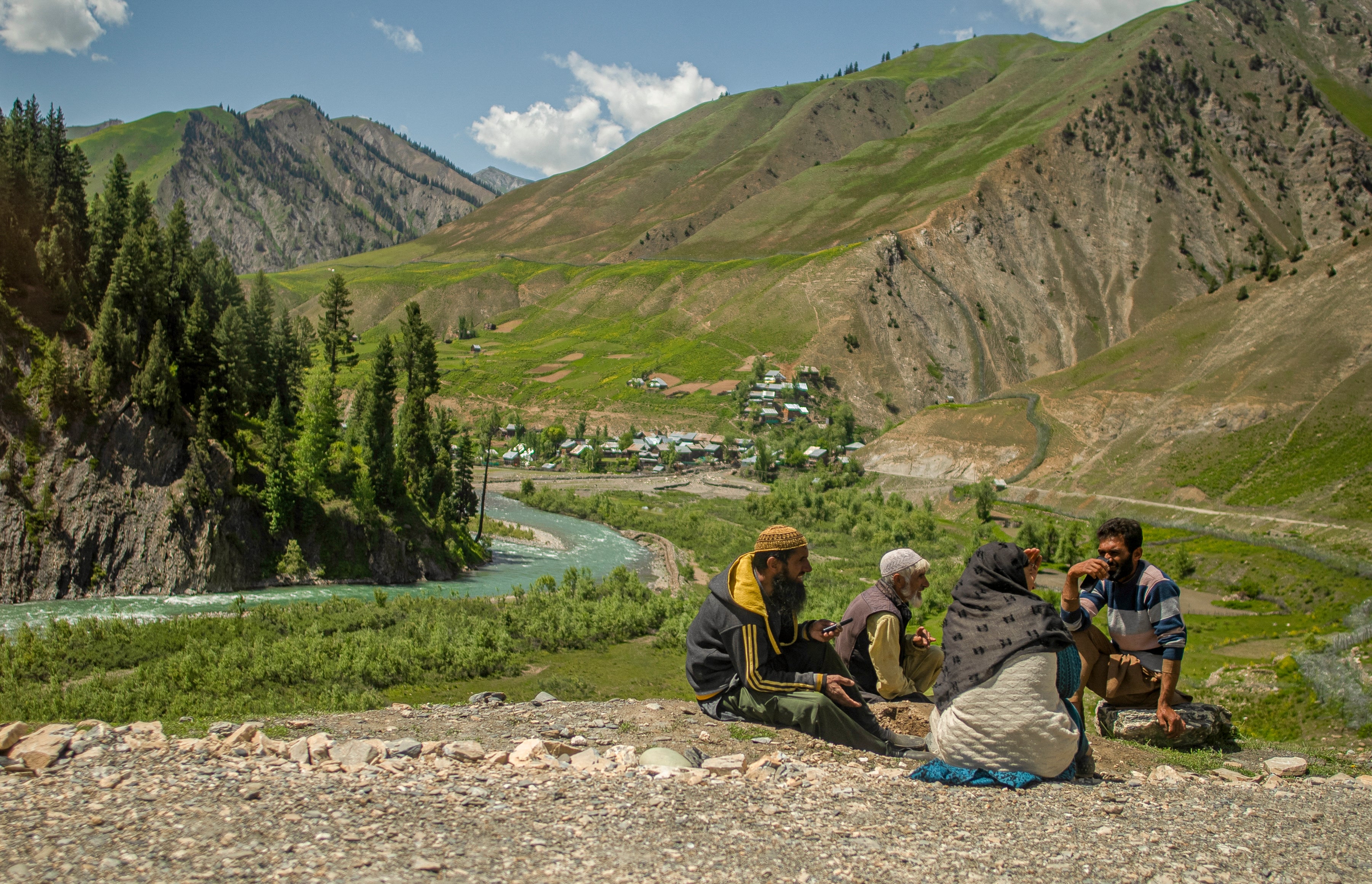 Local people sit on the side of the road with the view of the river in the Gurez valley in Bandipora, India-administered Jammu and Kashmir, near India-Pakistan border on 5 June 2025 (AFP/Getty)