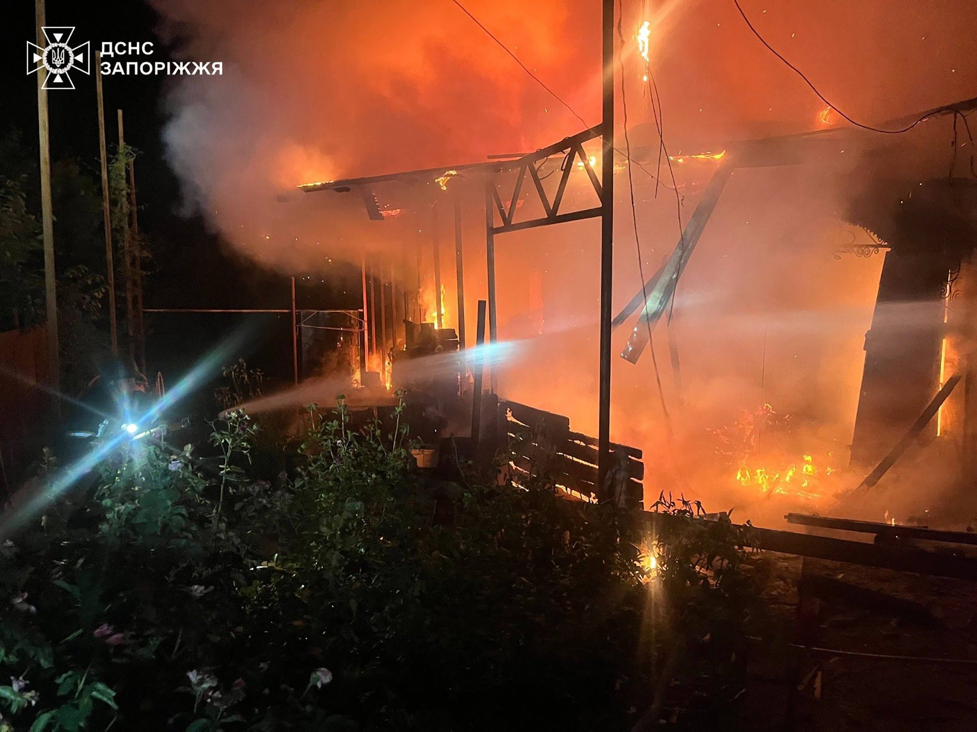 Emergency services personnel work to extinguish a fire following a Russian air attack in in Zaporizhzhia region