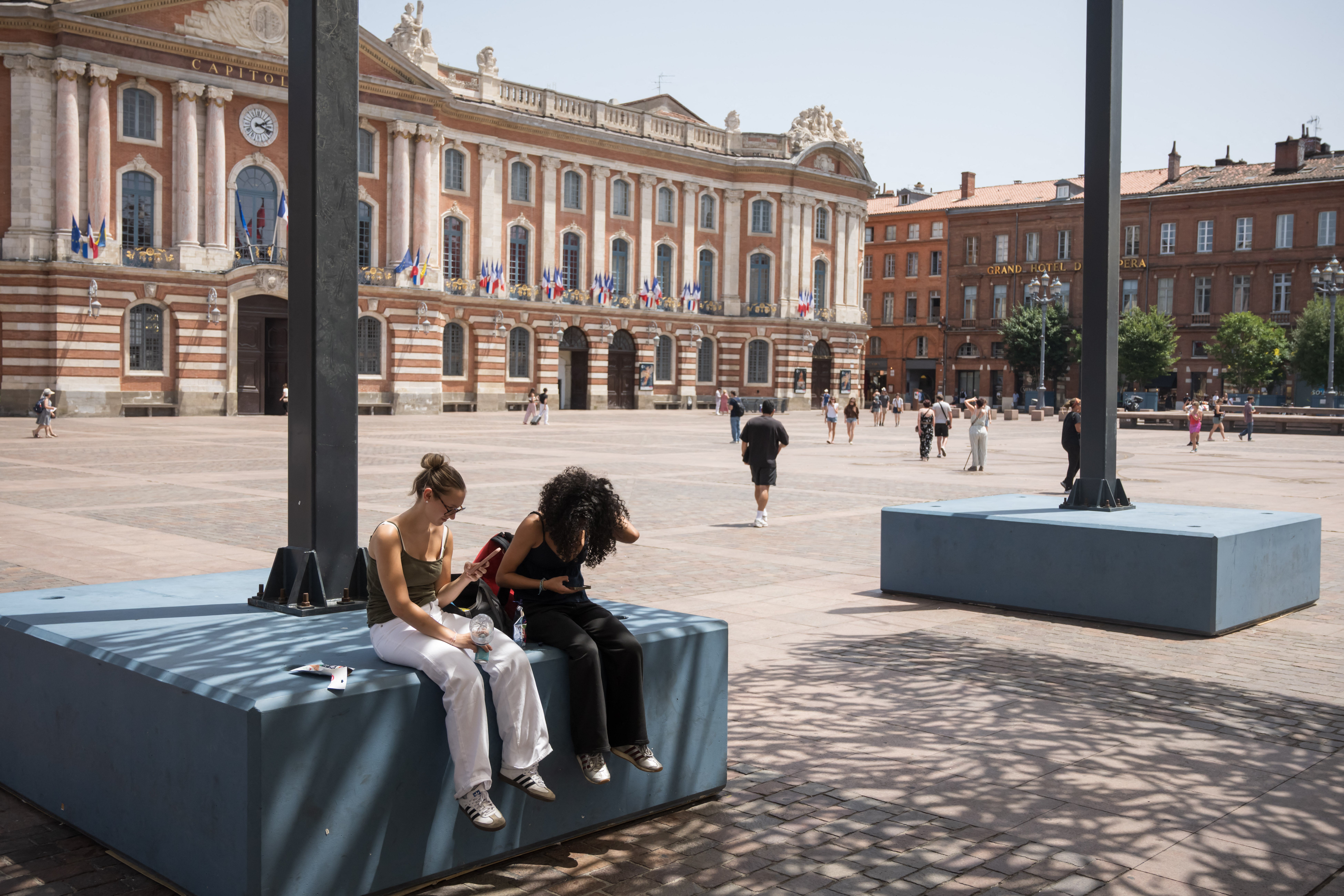 People sit in the shade in Toulouse during a heatwave on Monday