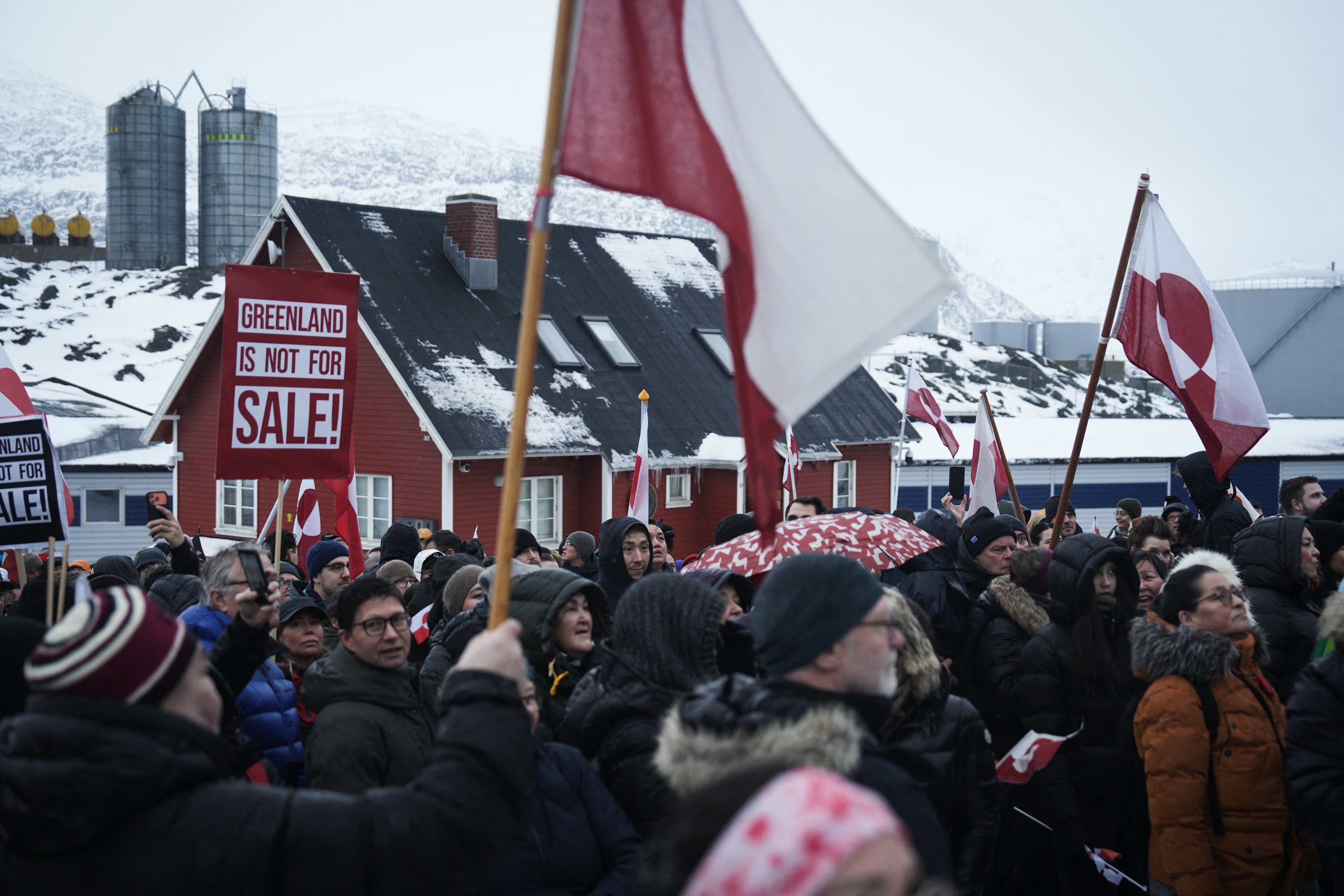 People wave Greenlandic flags as they take part in a demonstration that gathered almost a third of the city population to protest against the US President's plans to take Greenland, on January 17, 2026 in Nuuk, Greenland