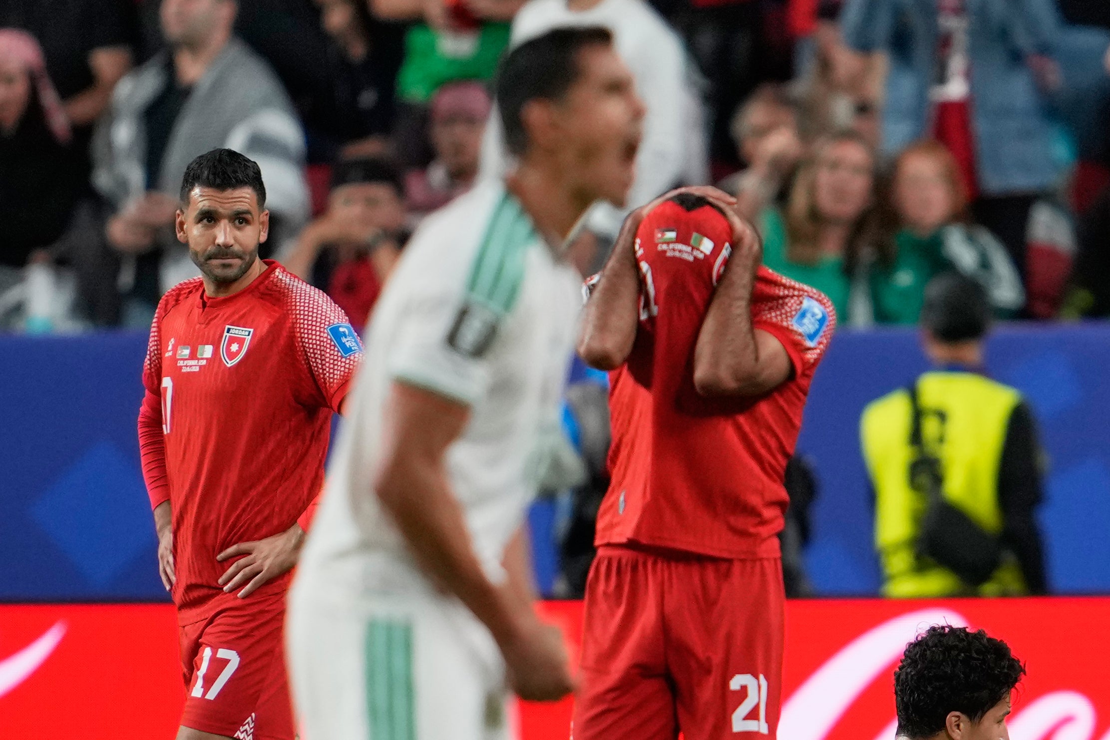 Jordan's Nizar Alrashdan (21), right, and Saleem Obaid (17), left, react after their loss to Algeria