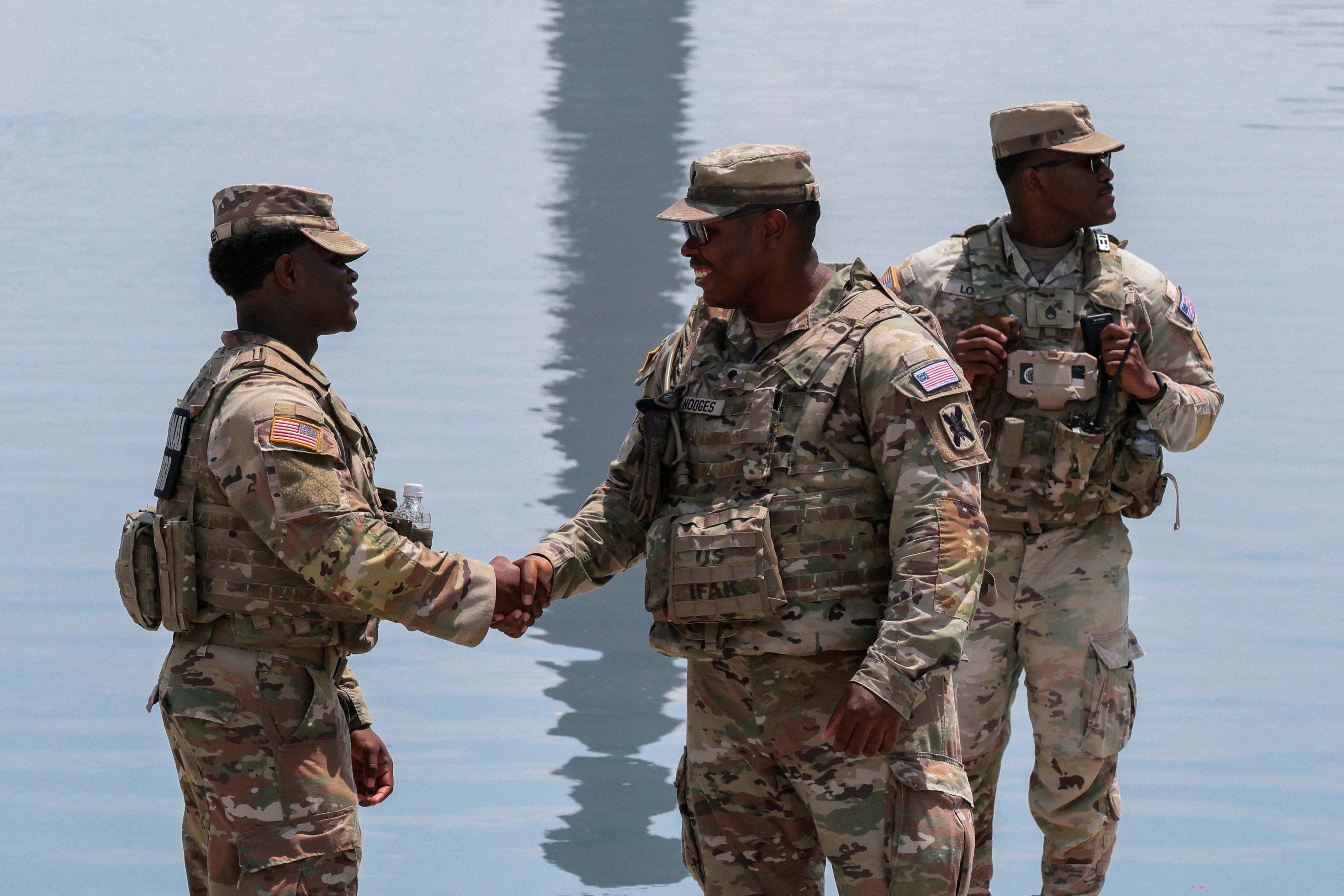 Members of the National Guard shake hands as they patrol the Lincoln Memorial Reflecting Pool (Reuters)