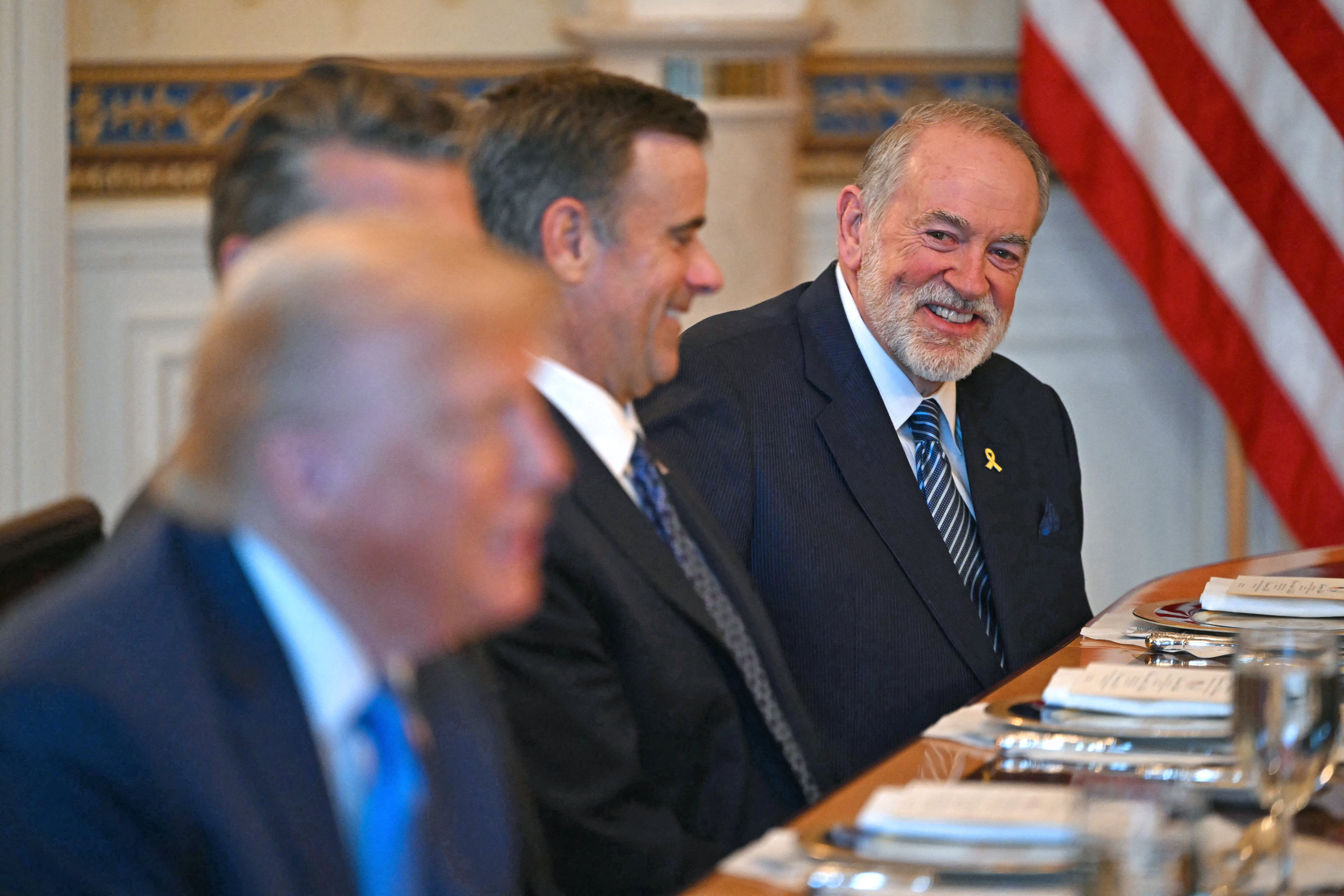 US Ambassador to Israel Mike Huckabee (R) smiles as US President Donald Trump (L) meets with unseen Israeli Prime Minister Benjamin Netanyahu at the Blue Room of the White House in Washington, DC, on July 7, 202