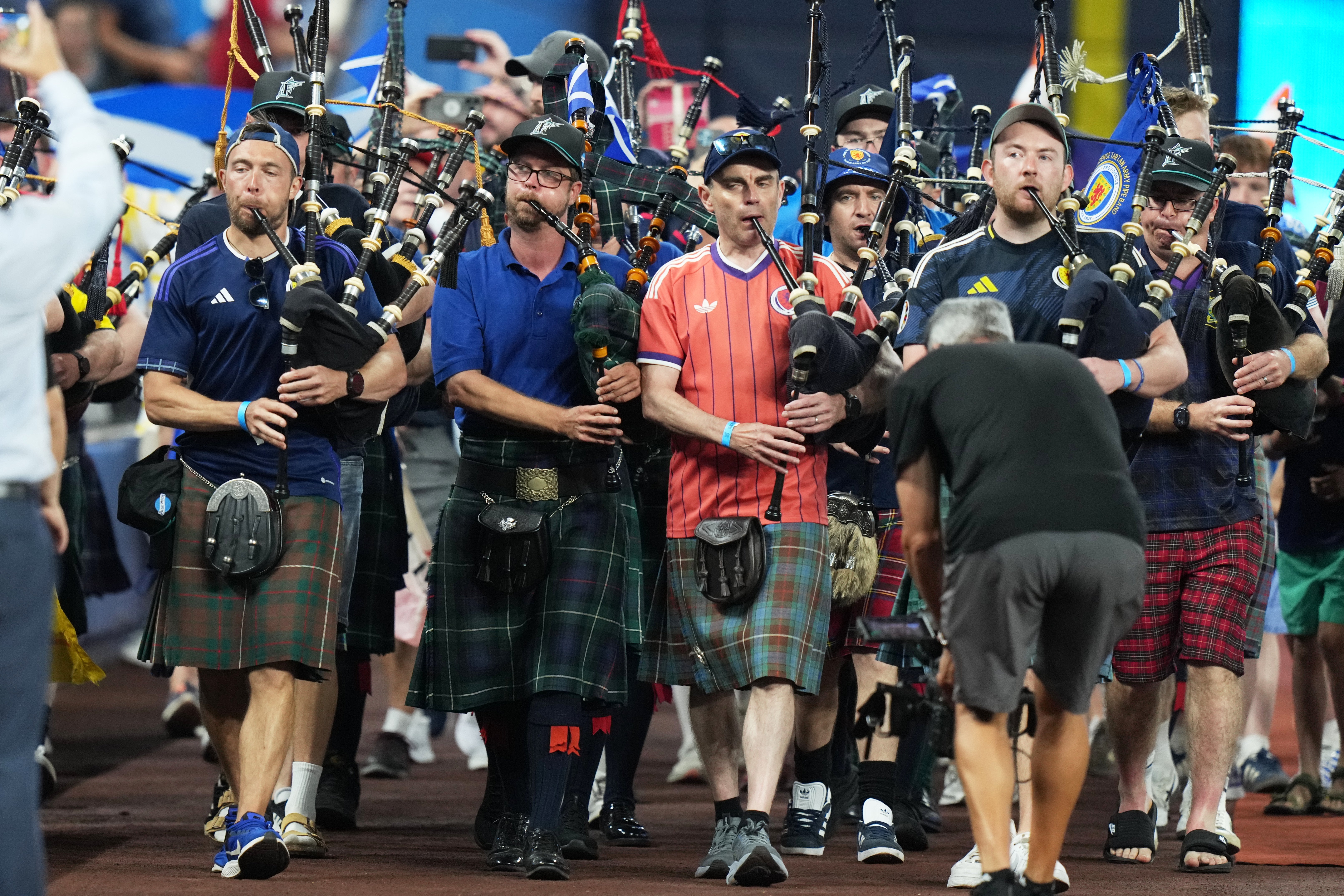 A bagpipe band marches in the outfield of LoanDepot Park in Miami.