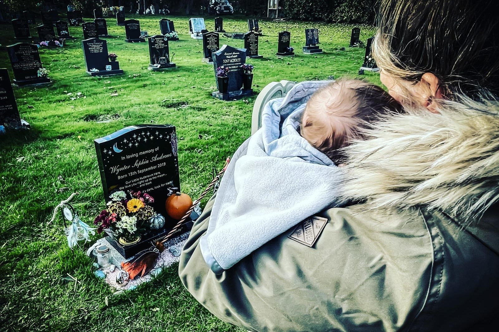 Sarah Andrews with her son Bowie at her daughter Wynter's grave (PA)