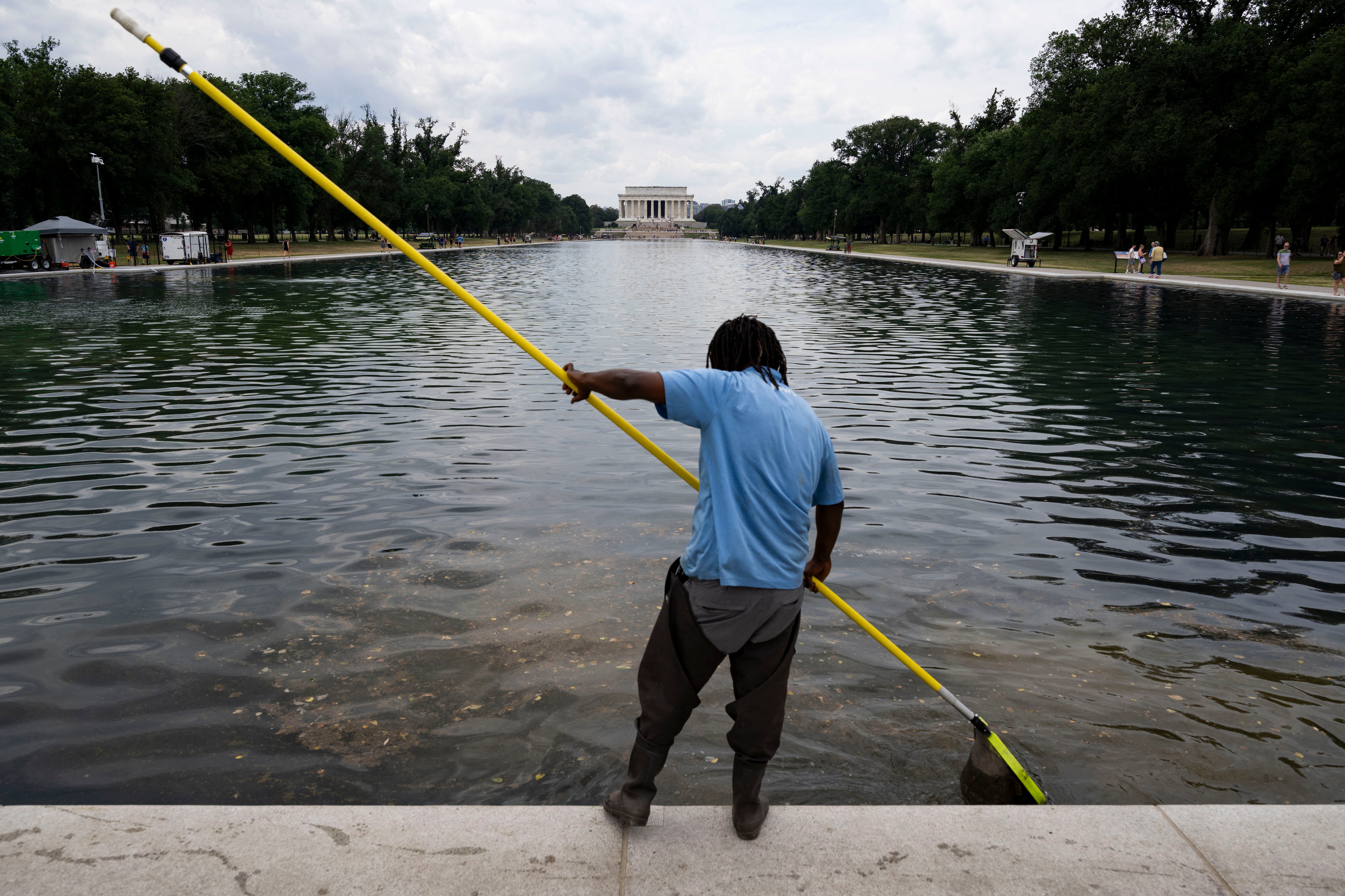 A worker cleans out algae and debris from the Reflecting Pool (AFP/Getty)