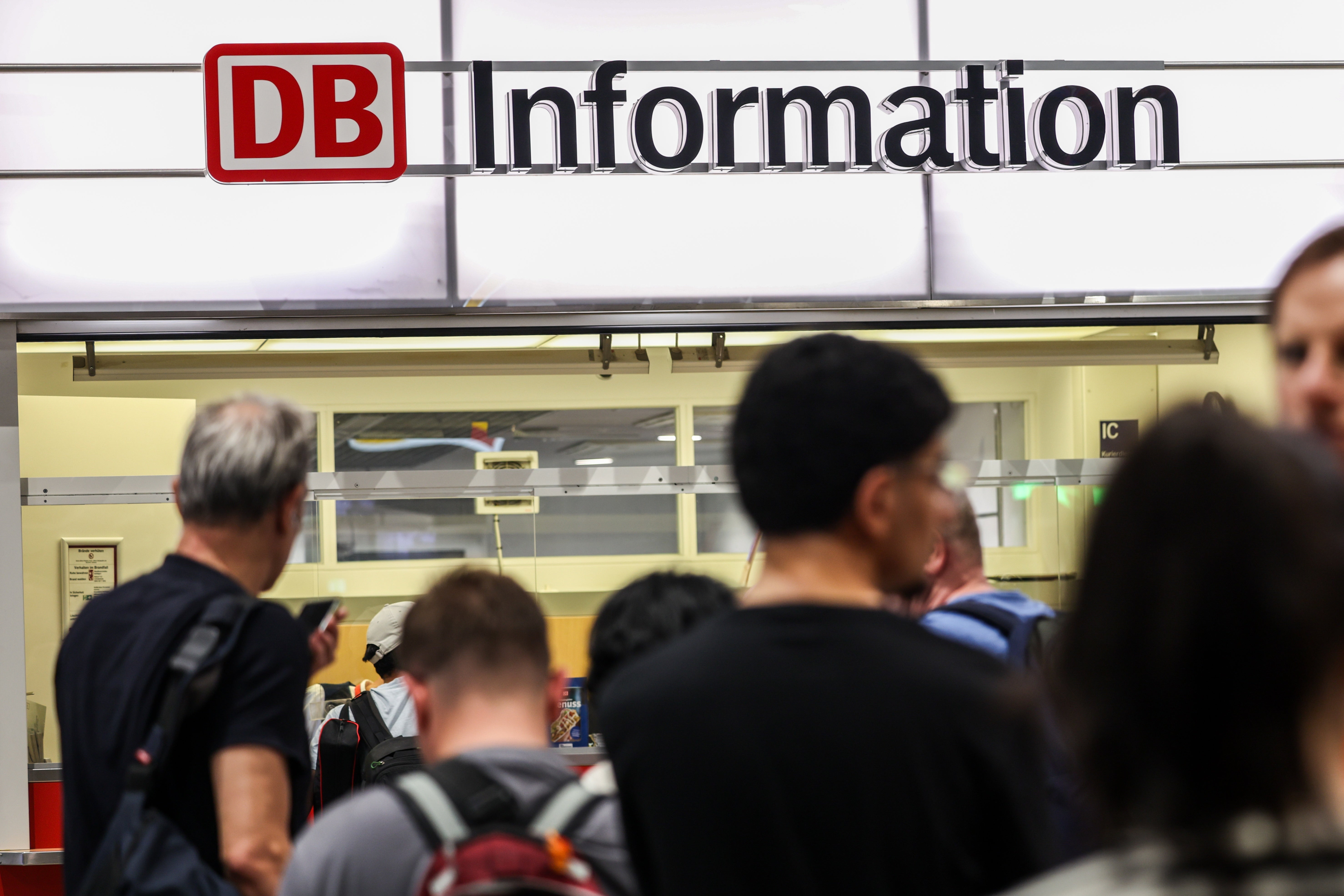 Passengers line up at the DB information desk at the Duisburg train station on Tuesday evening