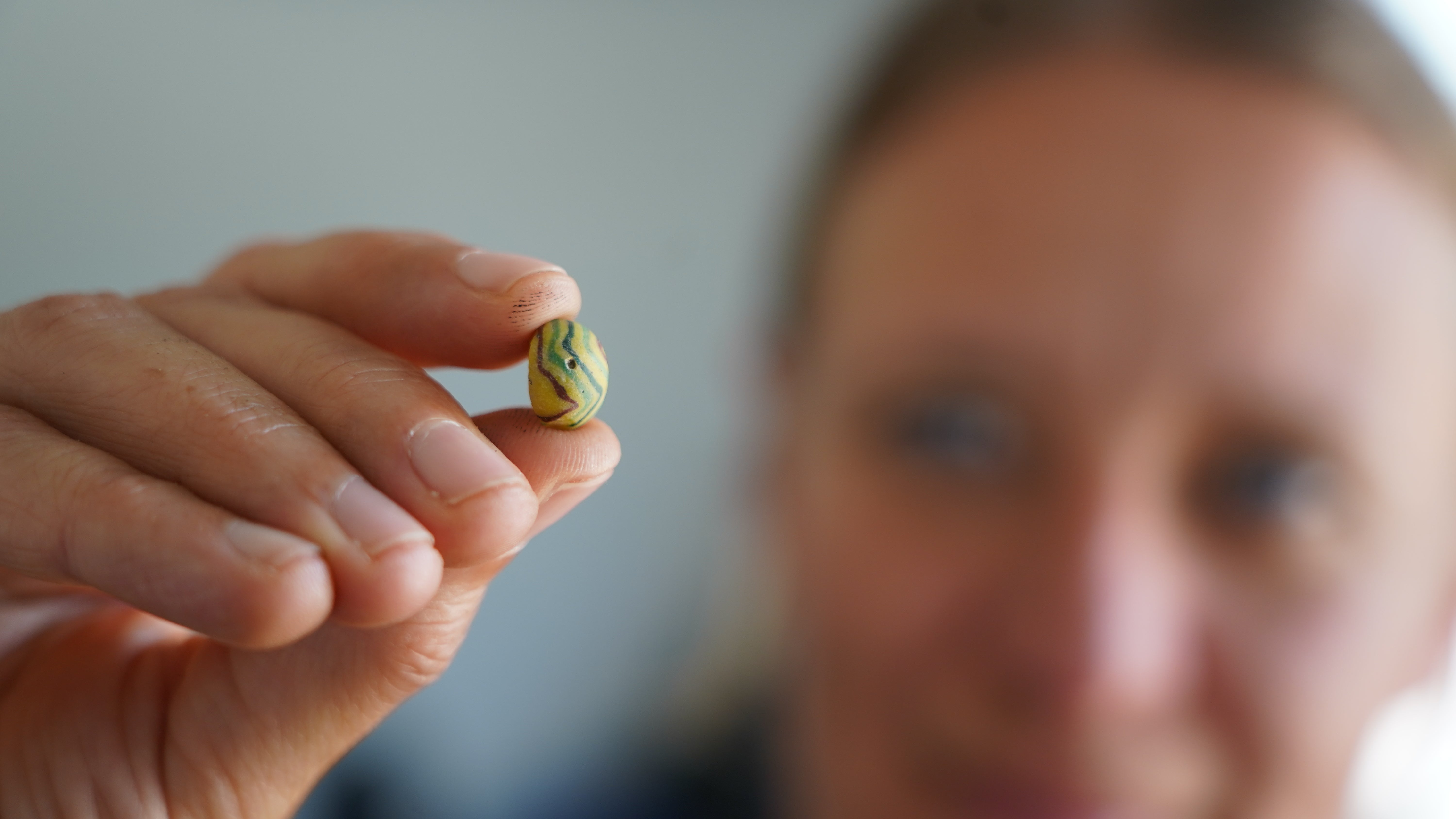 Moesgaard Museum archaeologist Liv Stidsing Reher-Langberg holds a Viking Age glass bead unearthed in Aarhus, Denmark