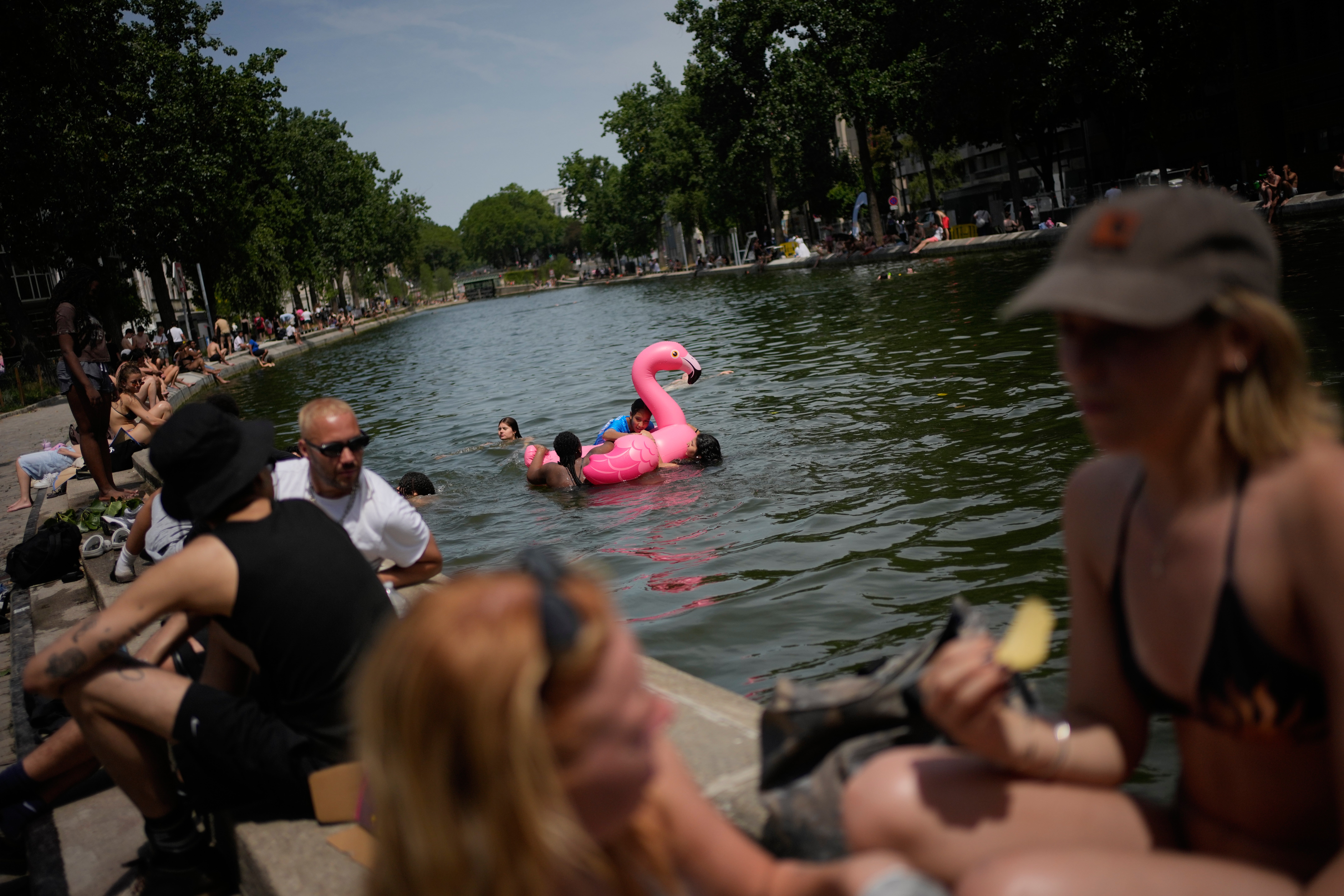 Parisians bath in the Canal Saint-Martin in Paris, as the national weather service, Meteo France, placed 54 departments, about half the country, under a red heat wave alert, Tuesday, June 23, 2026