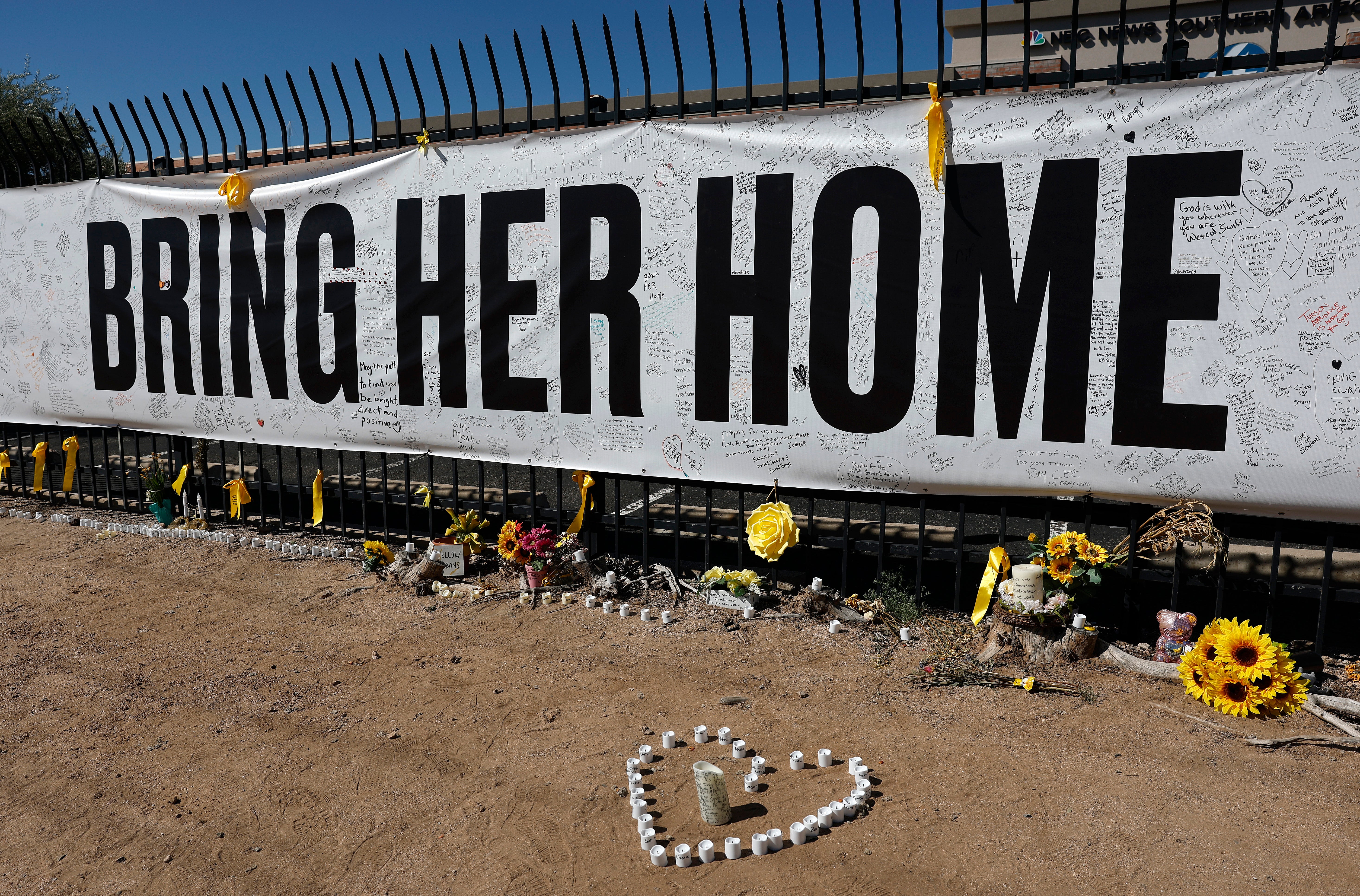 Candles and flowers are placed at a Nancy Guthrie memorial outside the KVOA newsroom in Tucson, Arizona