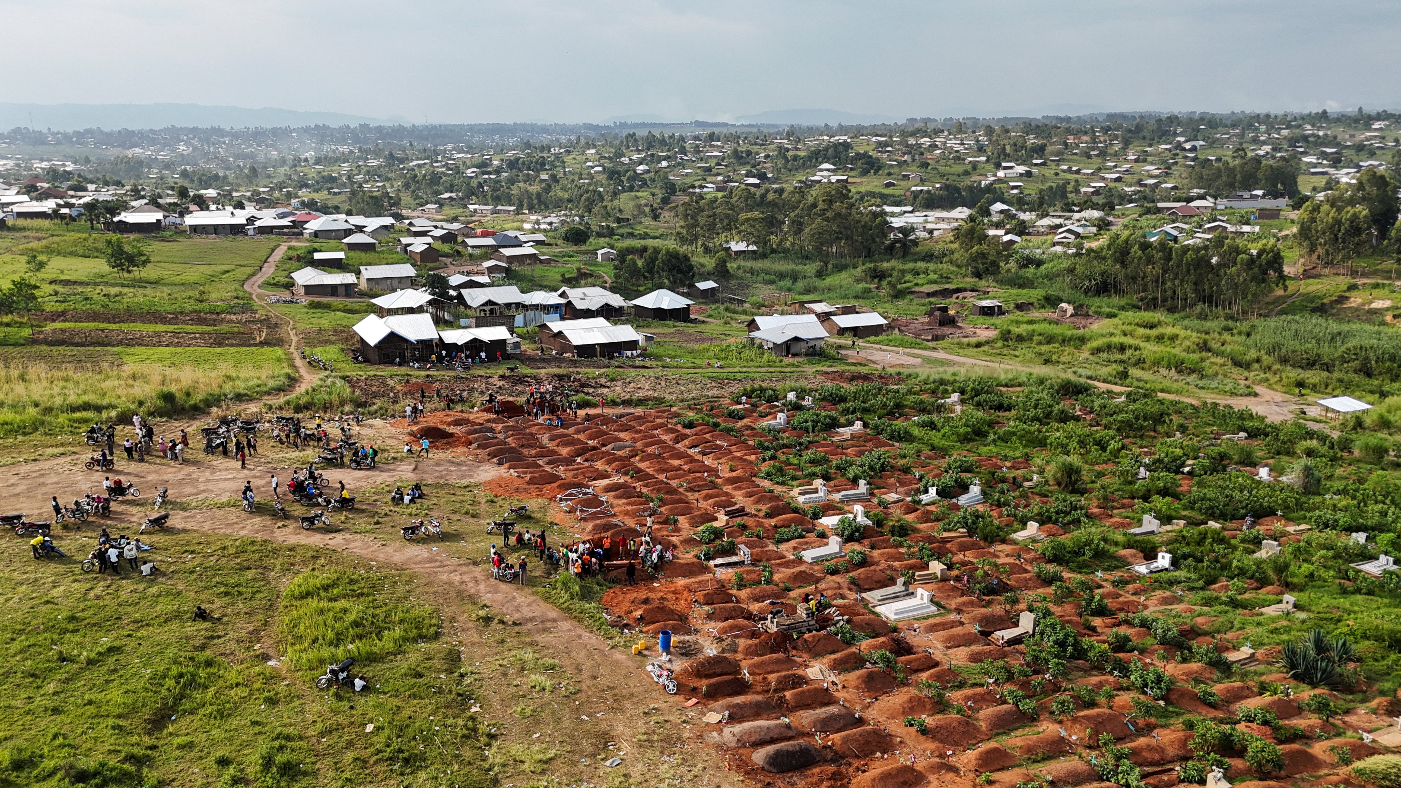 Displaced people from the Kigonze camp attending the burial of suspected Ebola victims at Nyamurongo Cemetery in Bunia on 18 June (Reuters)