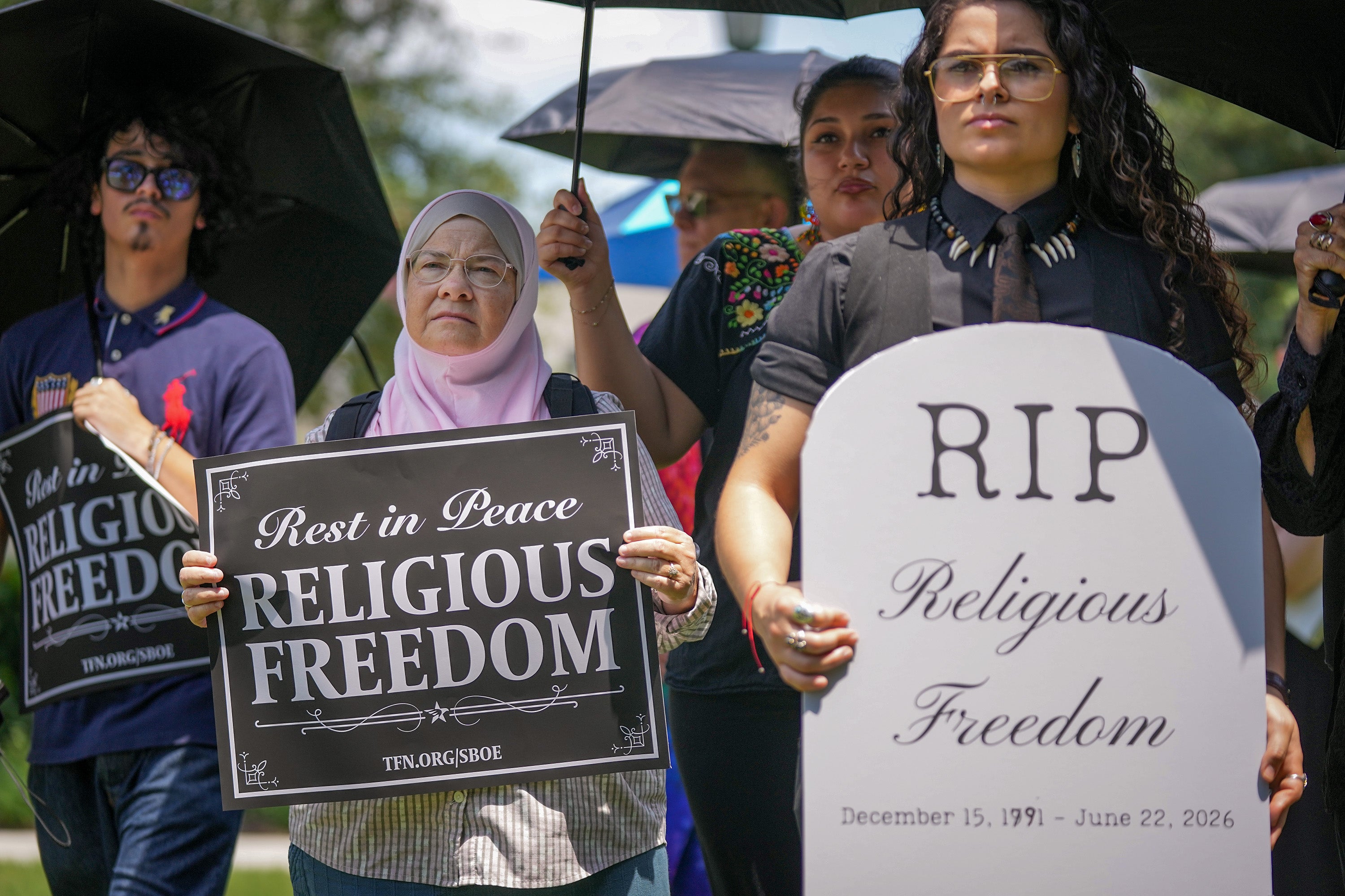 Ruth Nasrullah, left, and Rocio Fierro-Perez, political director for the Texas Freedom Network, participate in an interfaith funeral-themed protest outside the Barbara Jordan Building in Austin on Monday, June 22