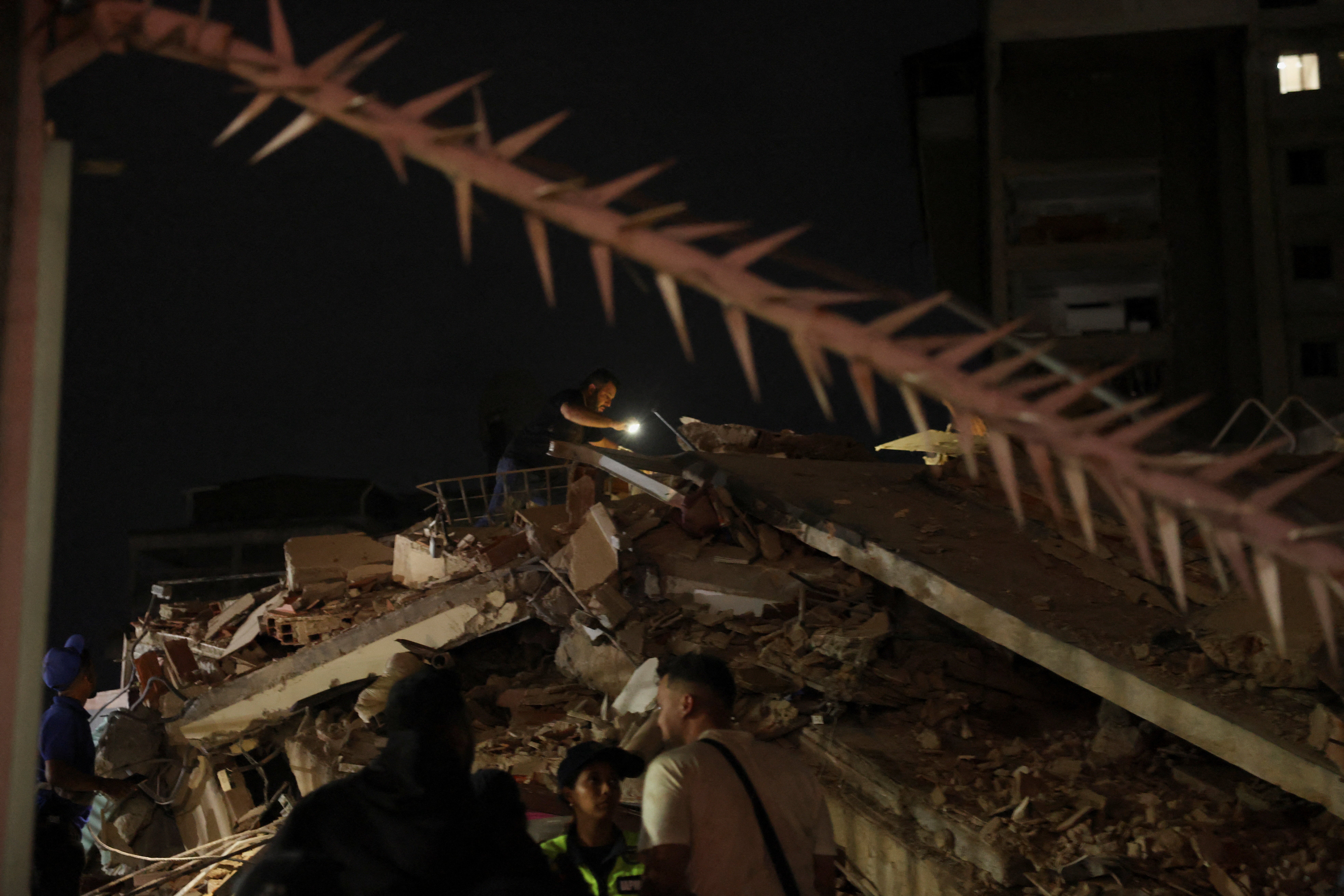 A person inspects the site of a collapsed building after an earthquake in Caracas, Venezuela, 24 June 2026