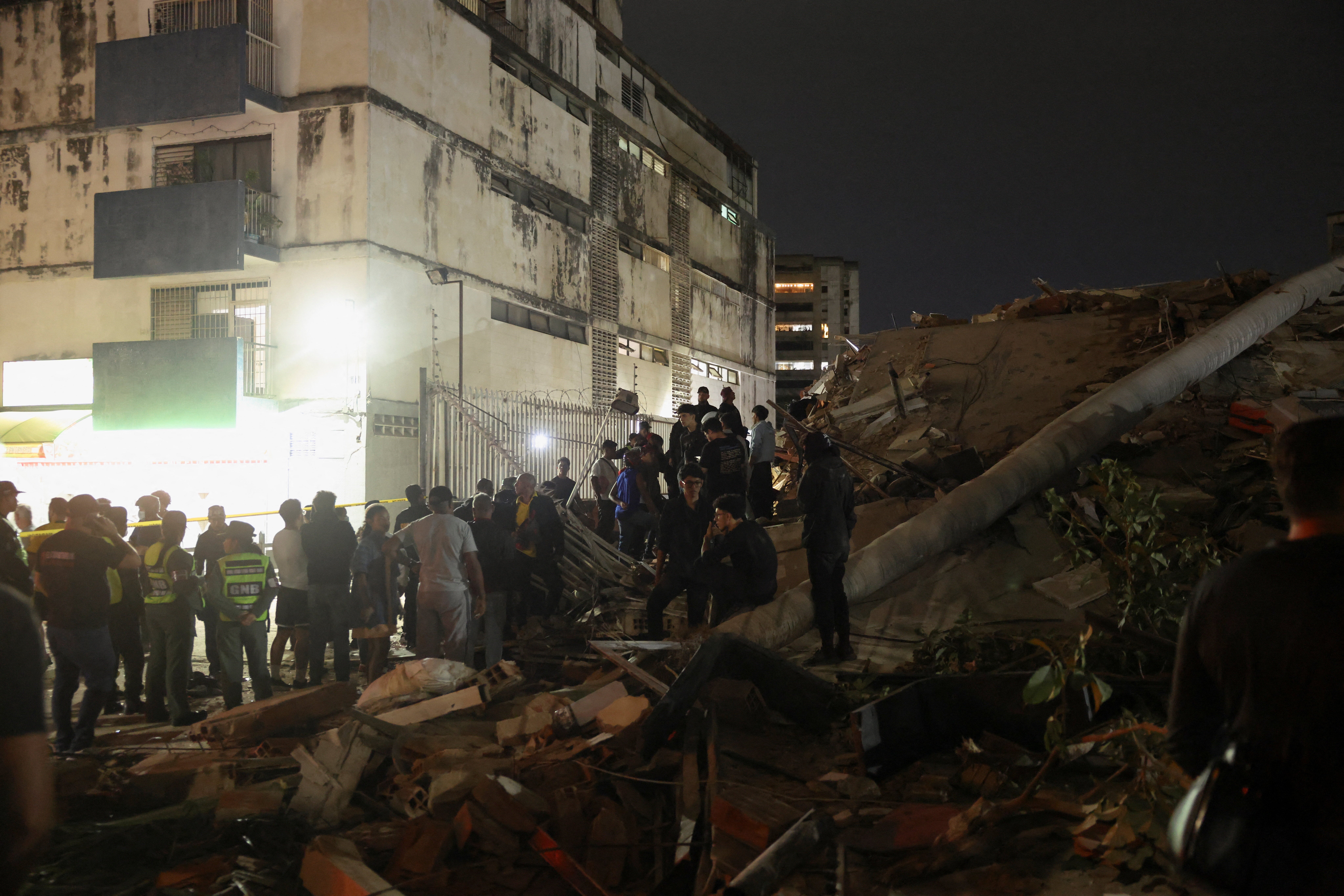 People gather at the site of a collapsed building after an earthquake in Caracas, Venezuela, 24 June 2026 (Reuters)