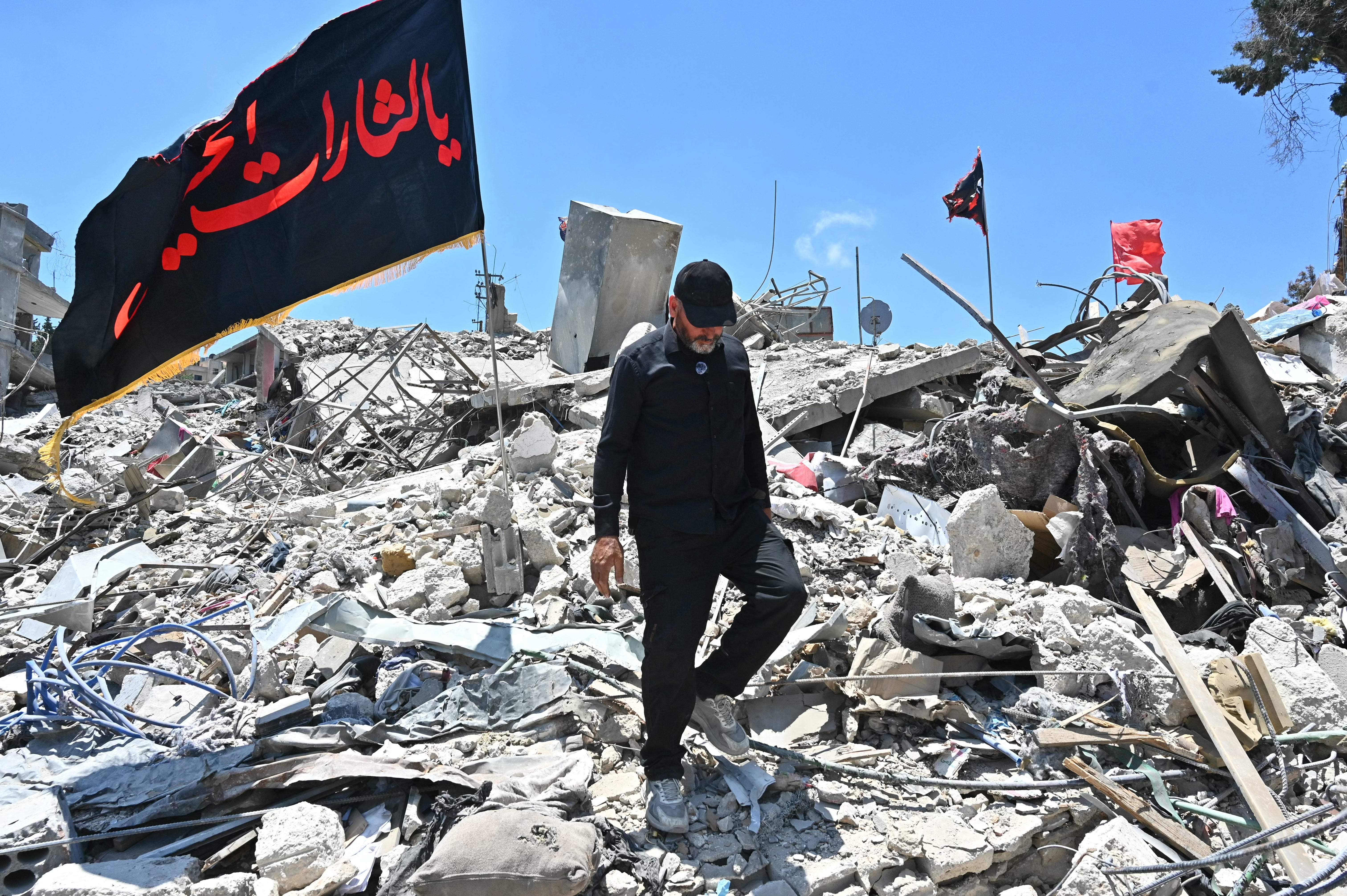 A resident walks on the rubble of homes and businesses, destroyed by the Israeli military, in the southern Lebanese village of Bir Al-Salasil on 24 June 2026