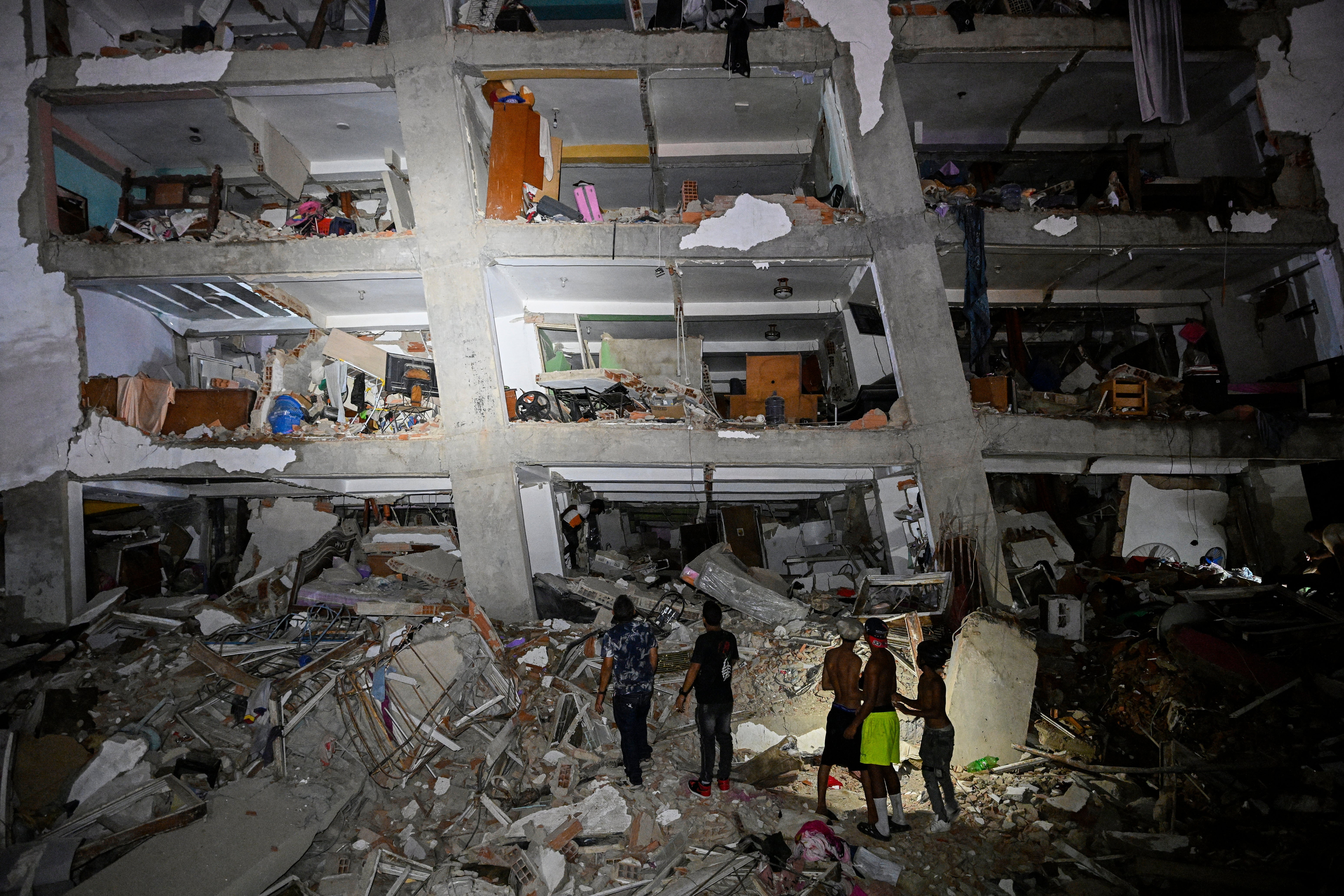 People stand in the rubble near a damaged building following an earthquake in Catia La Mar, La Guaira state, Venezuela (AFP/Getty)