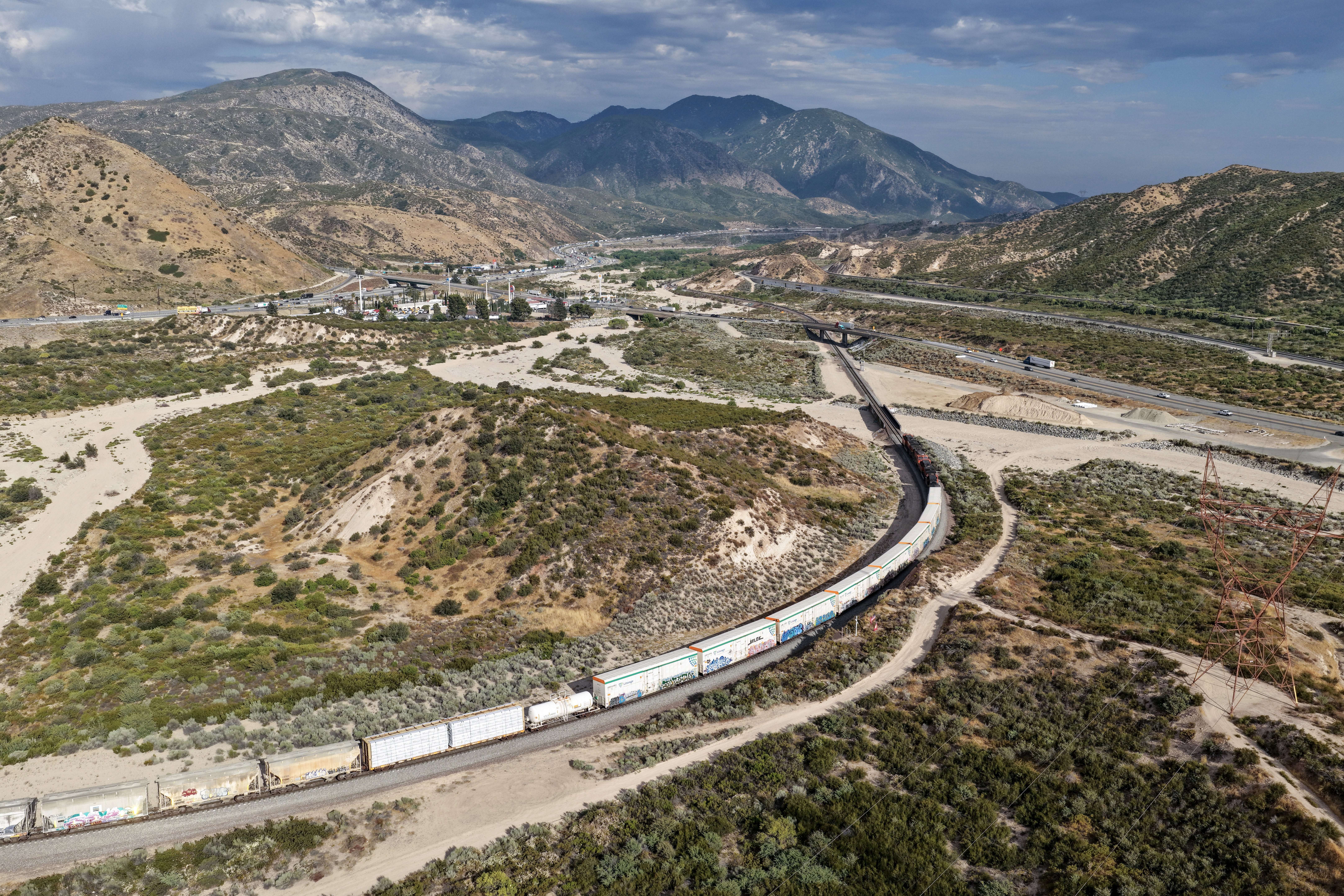 In an aerial view, a freight train is shown passing along the Cajon Pass near the San Andreas fault on June 23