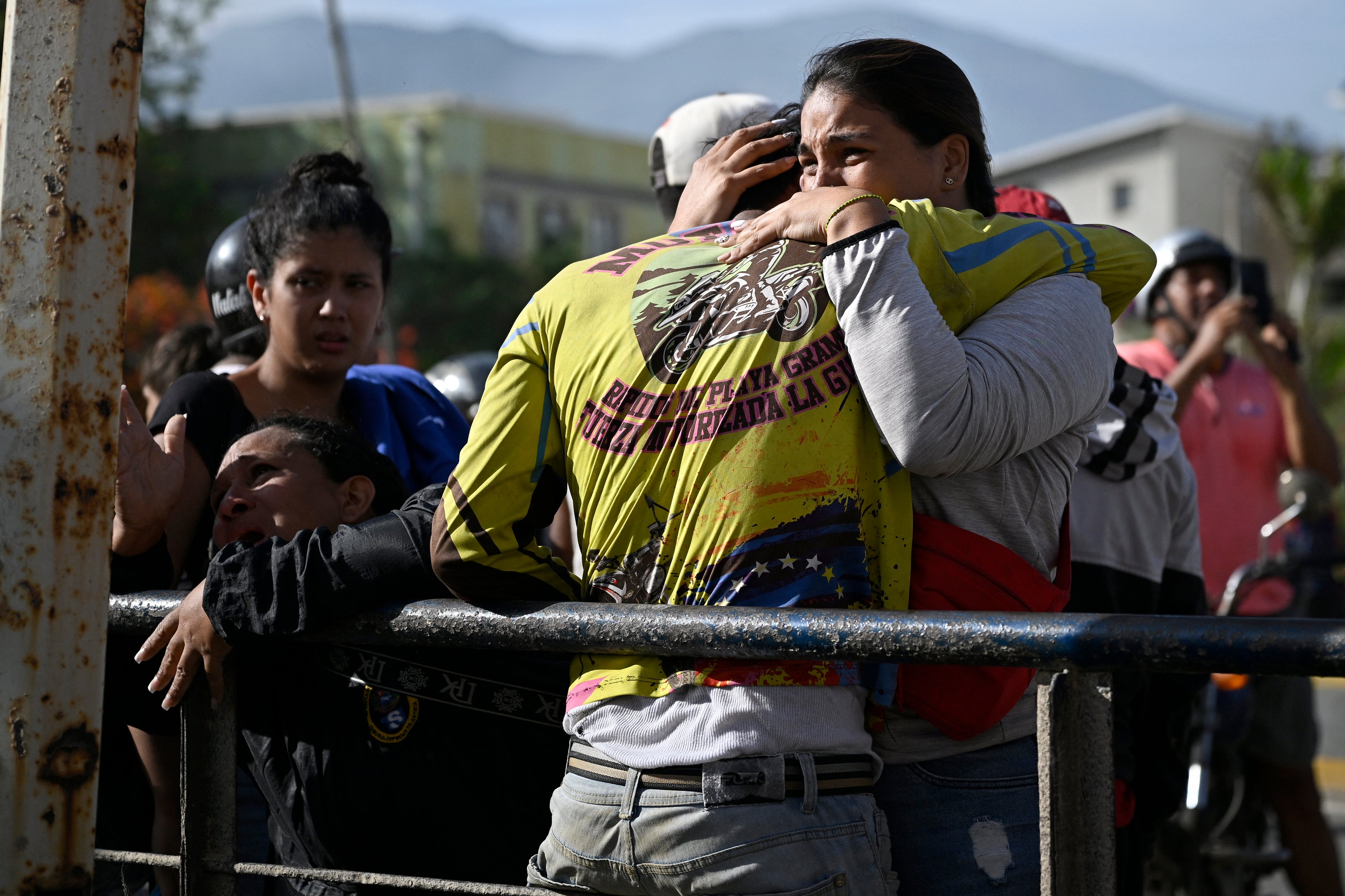 Distraught Venezuelans react near a damaged apartment building following an earthquake in Catia La Mar, La Guaira state