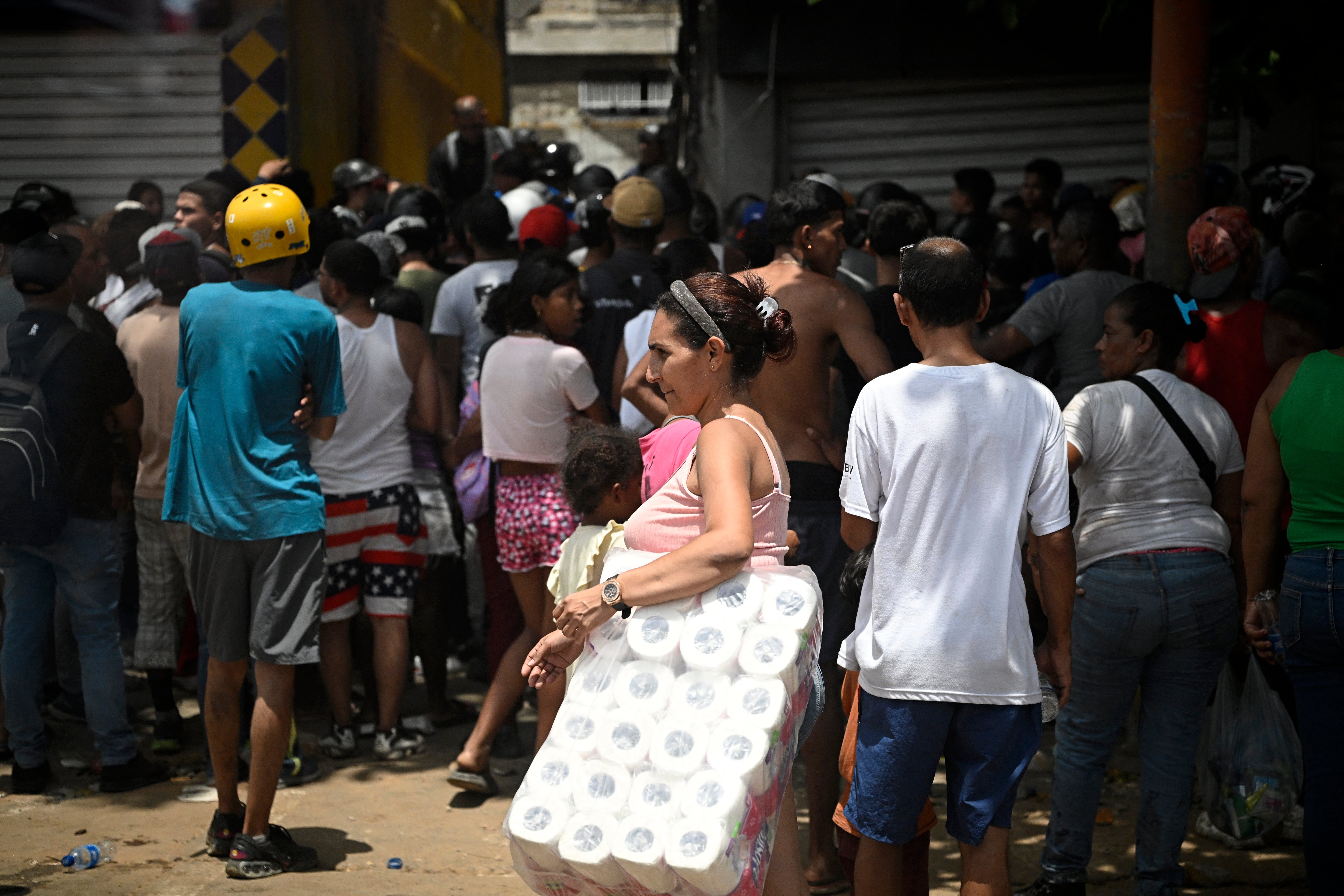 Residents gather outside a closed storefront in the aftermath of an earthquake in Catia La Mar